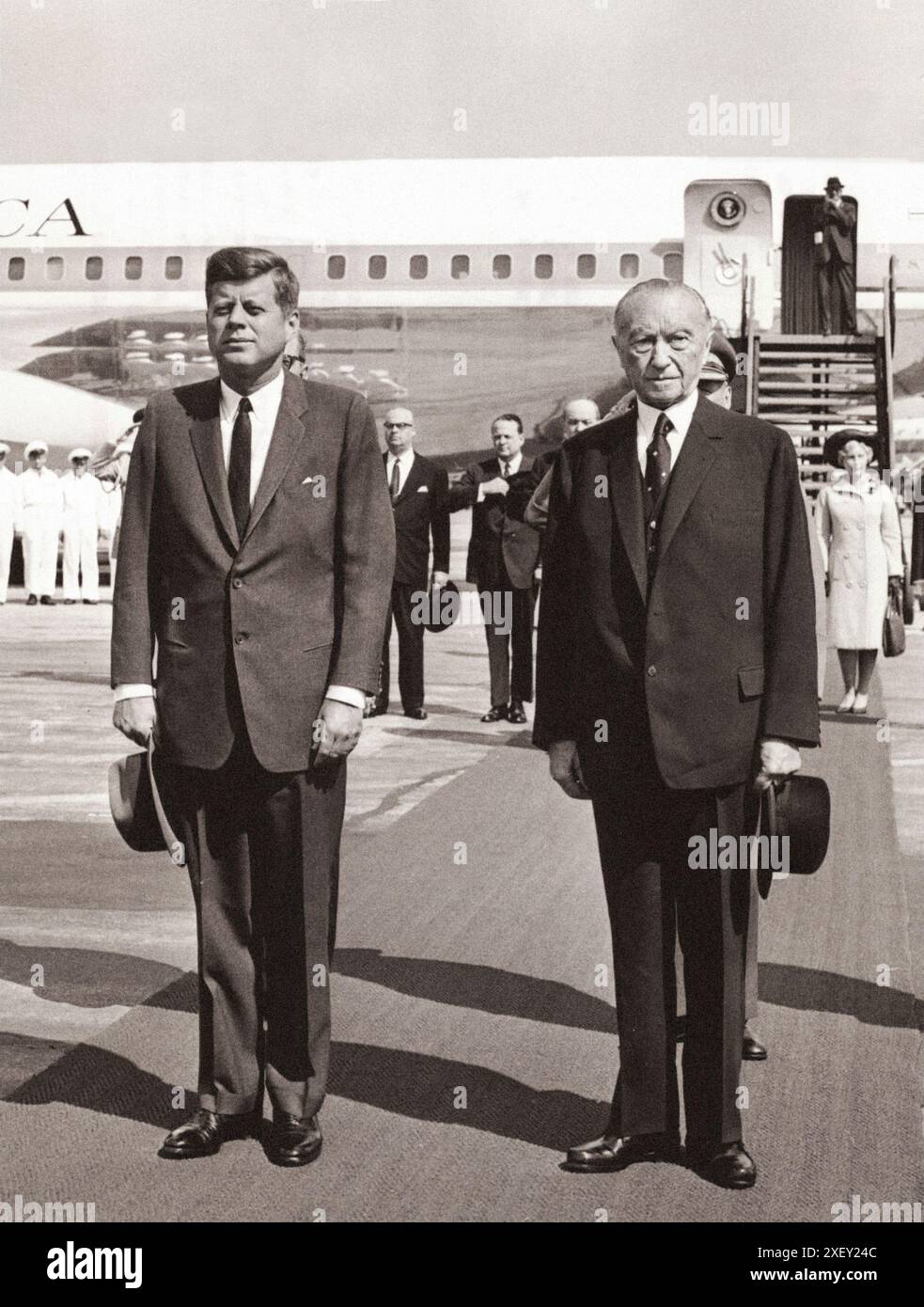 Vintage-Foto der Berliner Krise von 1961: Mauerbau. Präsident Kennedy und Bundeskanzler Adenauer stehen während des Auftritts der US-amerikanischen und deutschen Nationalhymnen unmittelbar nach der Ankunft des Präsidenten am Flughafen Wahn heute auf dem Spiel. Bundesrepublik Deutschland. Juni 1963 Stockfoto