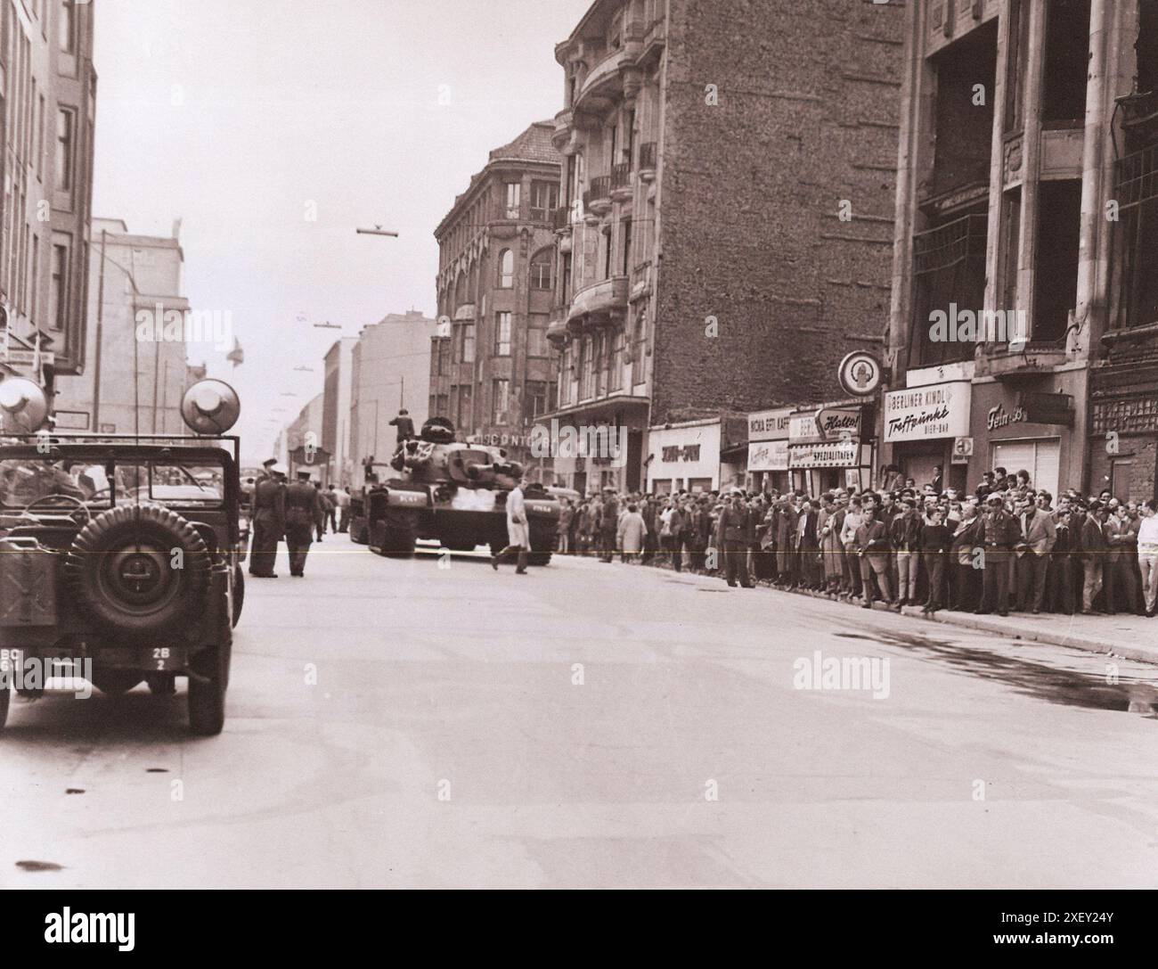 Vintage-Foto der Berliner Krise von 1961: Mauerbau. Patton-Panzer der Kompanie F, 40 Panzerung auf der Friedrichstraße, bedecken Schützlinge der 2. Battle Group, 6. Infanterie, die die Sektorgrenze bemannt (aus dem Bild). Die Massen interessierter West-Berliner werden von der West-Berliner Polizei kontrolliert. August 1961 Stockfoto