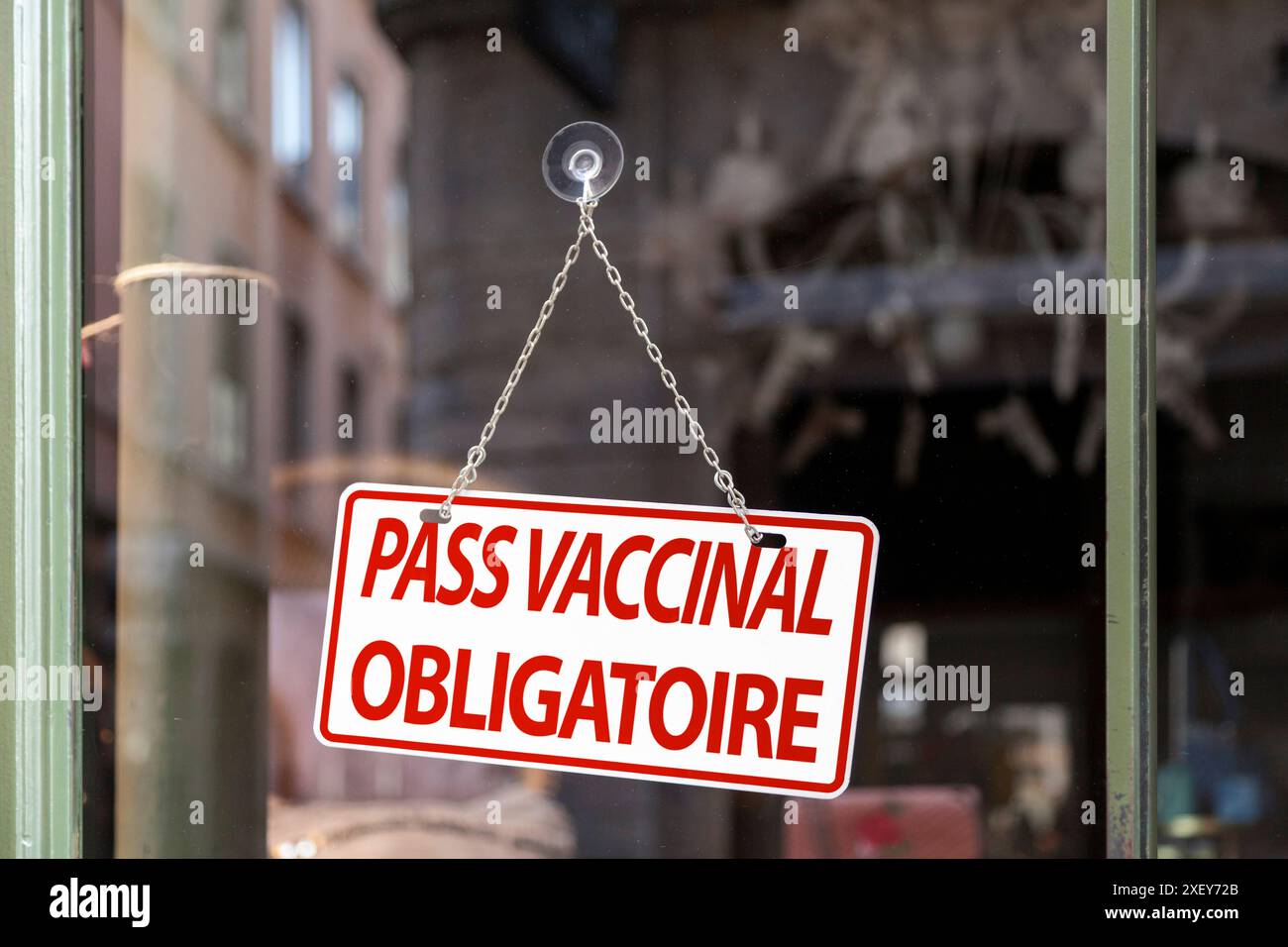 Nahaufnahme auf einem rot-weißen Schild in einem Fenster mit französischer Schrift „Pass Vaccinal obligatoire“, was im Englischen „obligatory Vaccinal Pass“ bedeutet. Stockfoto