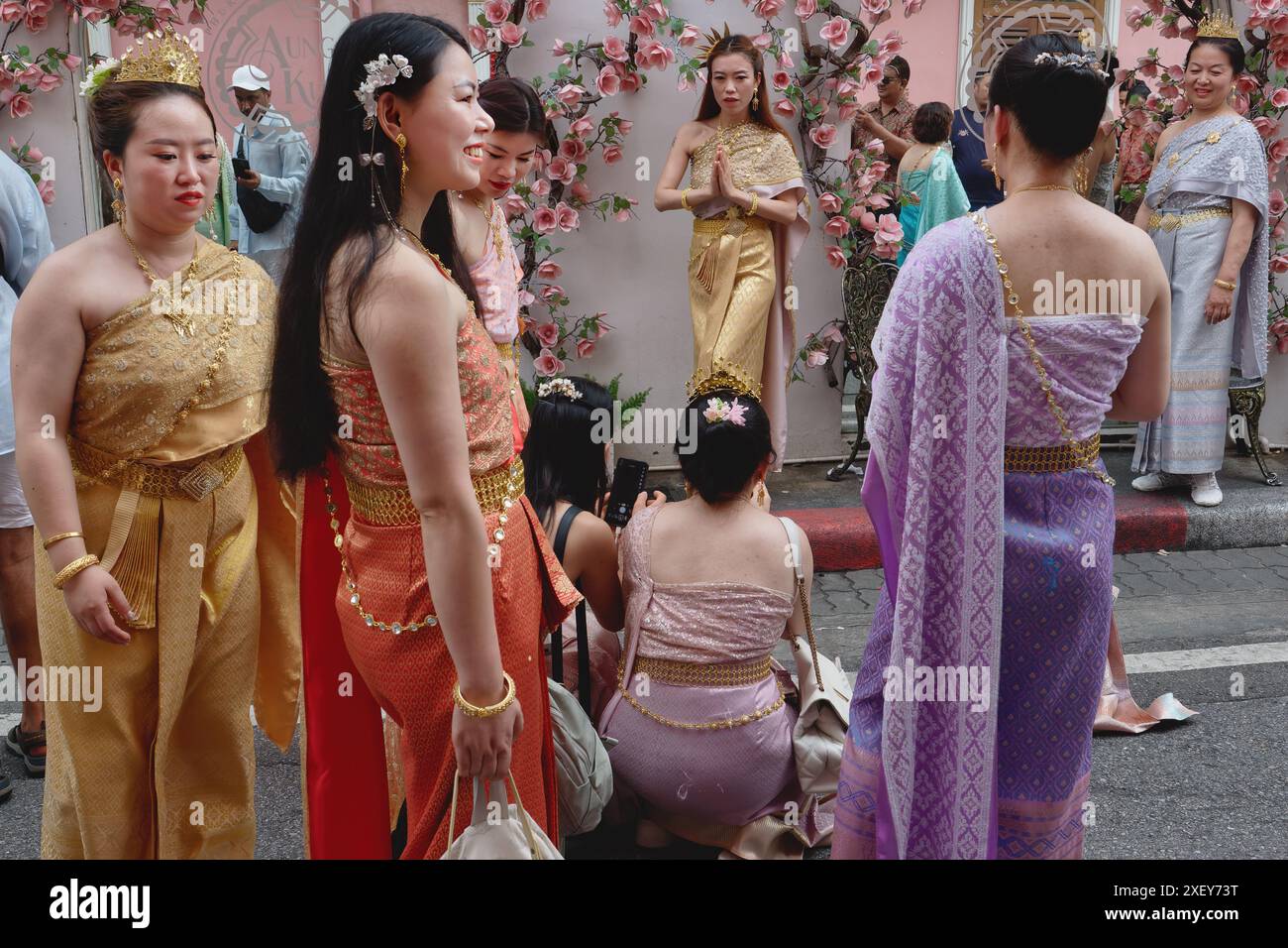 Thailändische Touristen in Soi Rommani in der Altstadt von Phuket Town, Thailand, posieren für Fotos in traditioneller thailändischer Tracht Stockfoto
