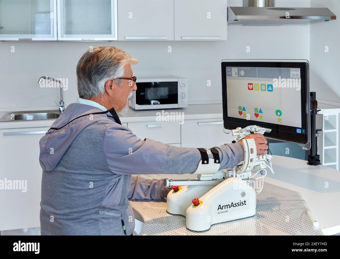 Patient mit assistivem Roboter für die Rehabilitation der oberen Gliedmaßen ermöglicht der Roboter ArmAssist passives, assistiertes und aktives Training von Arm und Hand, allo Stockfoto