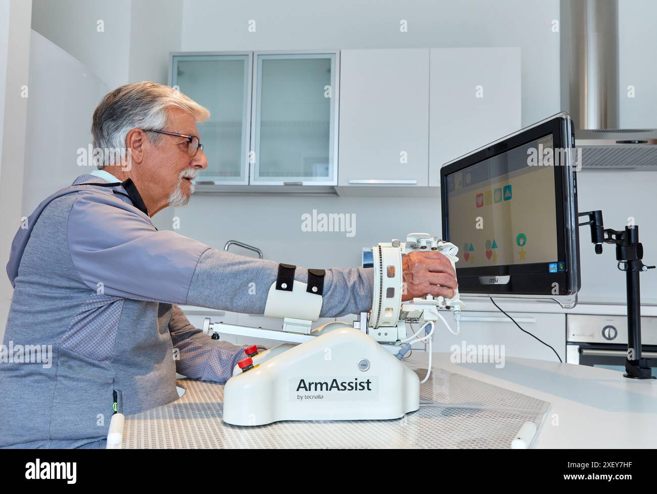 Patient mit assistivem Roboter für die Rehabilitation der oberen Gliedmaßen ermöglicht der Roboter ArmAssist passives, assistiertes und aktives Training von Arm und Hand, allo Stockfoto