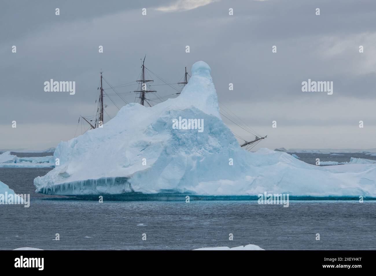 Bark Europa Segelschiff hinter dem Eisberg in der Antarktis. Stockfoto