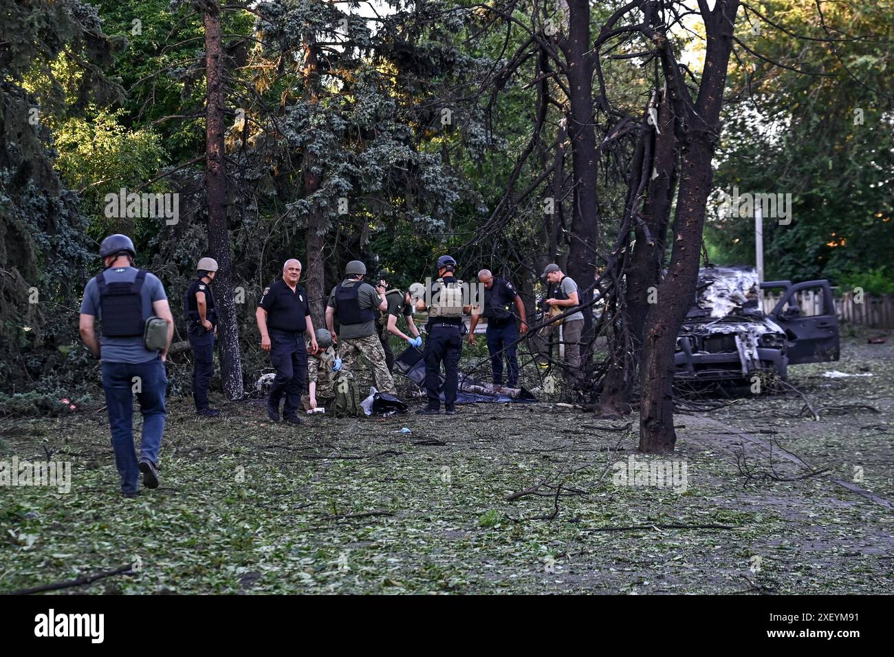 VILNIANSK, UKRAINE - 29. JUNI 2024 - Kriminelle untersuchen die Leichen von Menschen, die durch den russischen Raketenangriff in Zentral-Vilniansk, Region Zaporischschschhia, Süd-Ukraine getötet wurden. Russland startete am Samstag, 29. Juni um 17:40 Uhr Ortszeit Raketen im Zentrum von Vilniansk, einer Stadt in der Nähe der Front in der Region Zaporischzhia. Der Angriff tötete sieben Menschen, darunter drei Kinder. 36 Menschen wurden verletzt, darunter neun Kinder. Stockfoto