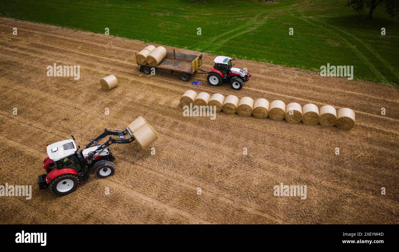 30.06.2024, Handenberg, AUT, unterwegs in Oberösterreich, Themenbild, Verschiedene Themenbilder, Symbolbild, Landwirtschaft, Bauern bei der Feldarbeit, Getreideernte, Landwirtschaft, Agrarwirtschaft, im Bild Traktor, Stroh einbringen, Strohballen Stroh Ballen, Presse, Landwirtschaft, Stroh, Strohpresse, Großballenpresse, Großballen, Strohpressen, Stroh pressen, *** 30 06 2024, Handenberg, AUT, unterwegs in Oberösterreich, Themenbild, verschiedene Themenbilder, Symbolbild, Landwirtschaft, Landwirte, die auf dem Feld arbeiten, Getreideernte, Landwirtschaft, Traktor im Bild, Bringin Stockfoto