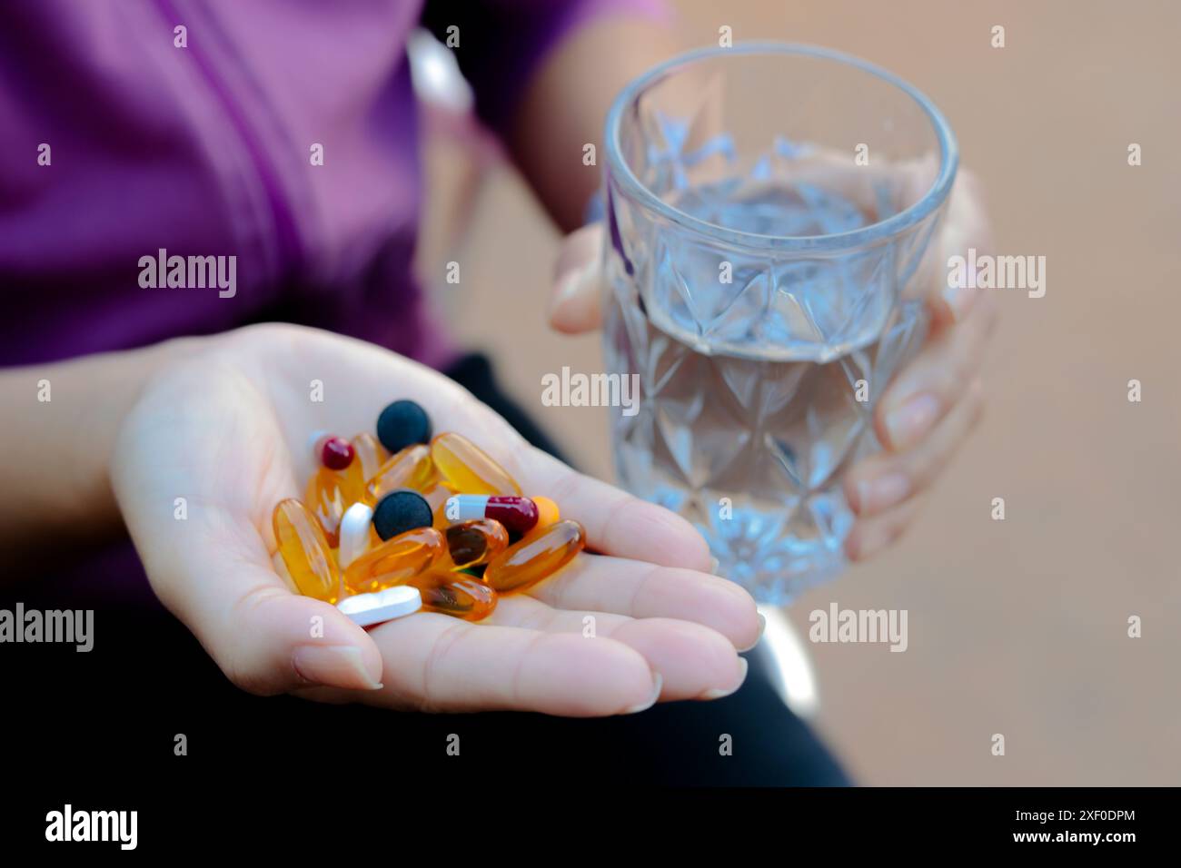 Luque, Paraguay. 30. Juni 2024. In dieser Fotoabbildung sind mehrere Medikamententabletten auf der Hand einer Person zu sehen, die ein Glas Wasser halten. (Foto von Jaque Silva/SOPA Images/SIPA USA) *** ausschließlich für redaktionelle Nachrichten *** Credit: SIPA USA/Alamy Live News Stockfoto