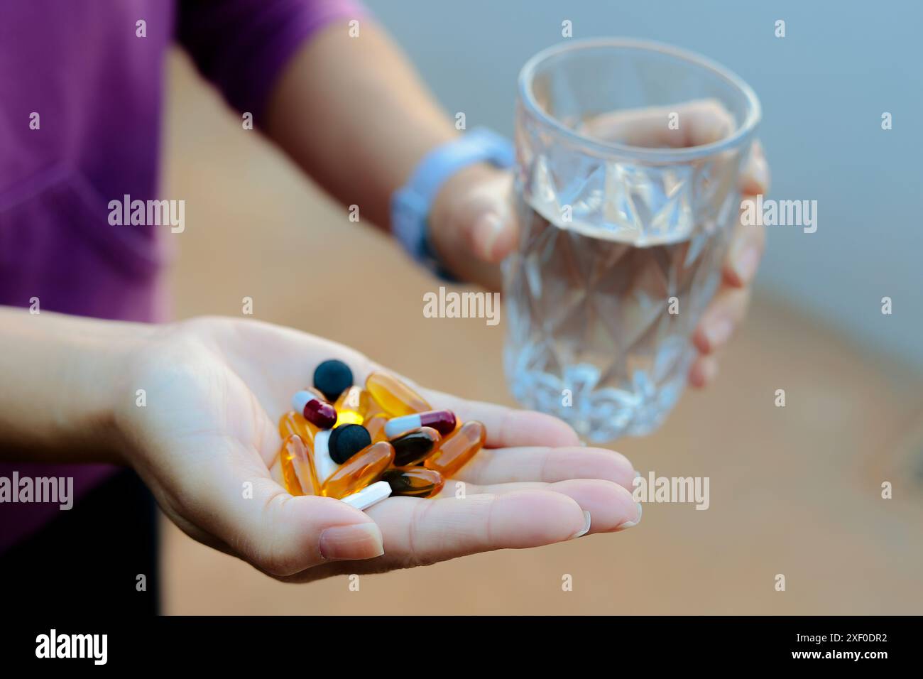 Luque, Paraguay. 30. Juni 2024. In dieser Fotoabbildung sind mehrere Medikamententabletten auf der Hand einer Person zu sehen, die ein Glas Wasser halten. (Foto von Jaque Silva/SOPA Images/SIPA USA) *** ausschließlich für redaktionelle Nachrichten *** Credit: SIPA USA/Alamy Live News Stockfoto