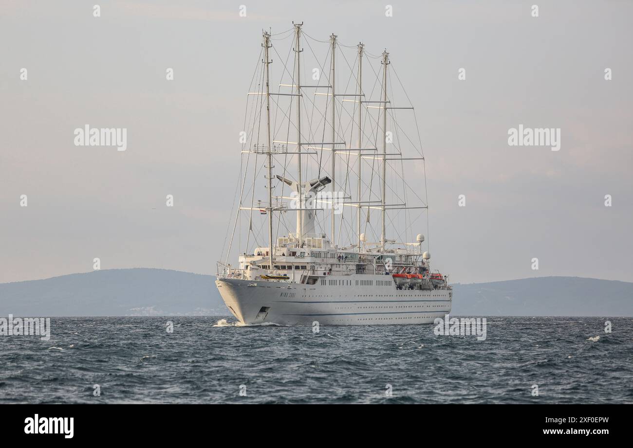 Korčula, Kroatien. 30. Juni 2024: Bei Tagesanbruch segelt das fünf-Masten-Kreuzfahrtschiff WINDSURF, eines der größten Segelschiffe der Welt, in der Adria und nähert sich der Insel Mljet. Das Schwesterschiff des French CLUB MED 2, früher als CLUB MED 1 bekannt, erreicht die Stadt Korcula nahe Dubrovnik an der dalmatinischen Küste. Windstar Cruises, der riesige Besitzer von Staysail-Schonern, hat eine mehrjährige Initiative gestartet, um seine Yachten der Wind-Klasse neu zu gestalten und zu renovieren: Wind Star, Wind Spirit & Wind Surf (Flaggschiff der Flotte), die Arbeiten an letzteren in zwei Phasen Ende 2024 und 2026. Quelle: Kevin Izorce/Alamy Live News Stockfoto