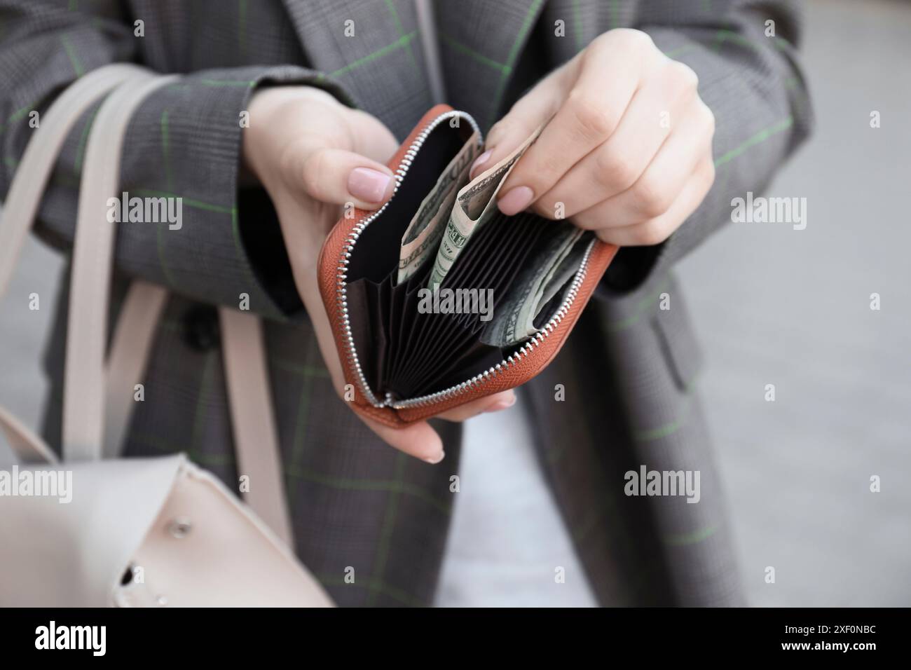 Frau mit Geldbörse mit Banknoten draußen, Nahaufnahme Stockfoto