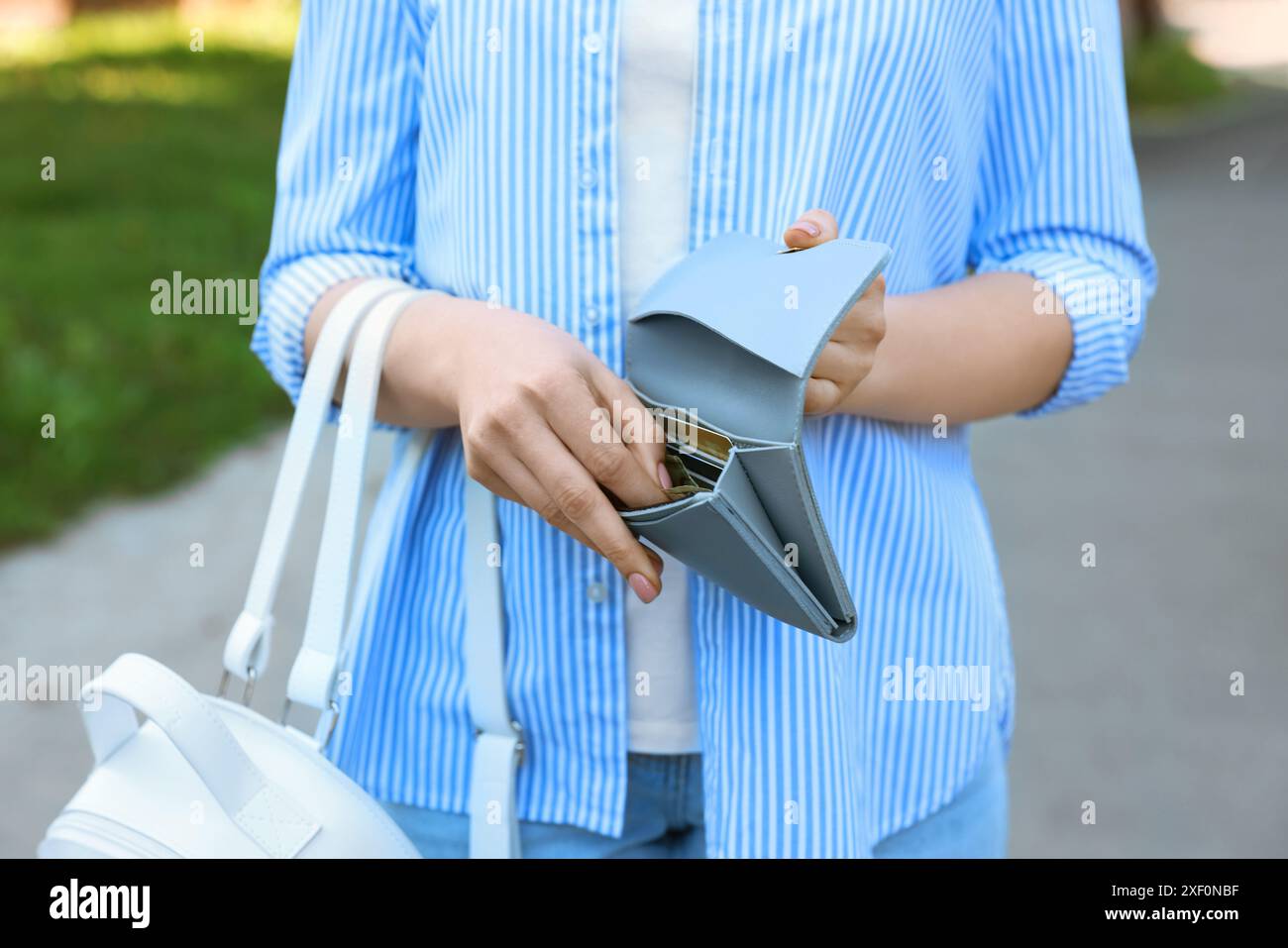 Frau mit Geldbörse mit Banknoten draußen, Nahaufnahme Stockfoto