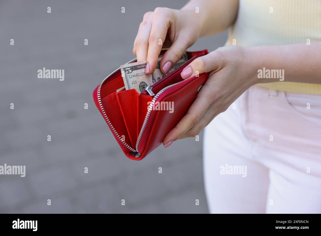 Frau mit Geldbörse mit Banknoten draußen, Nahaufnahme Stockfoto