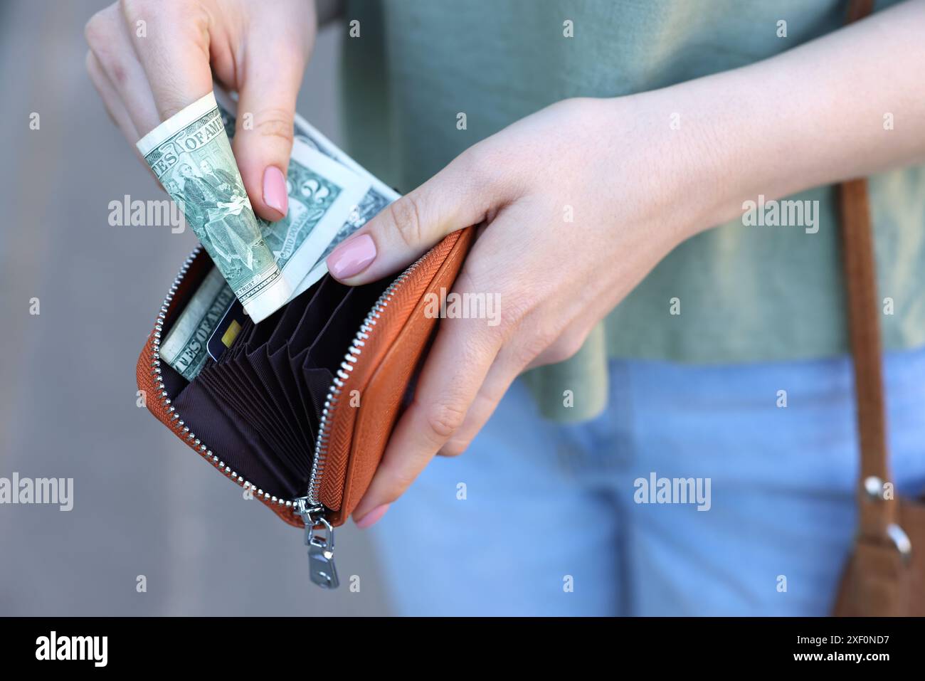 Frau mit Geldbörse mit Banknoten draußen, Nahaufnahme Stockfoto