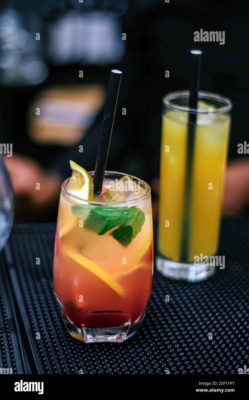 Cocktail mit Limette, serviert in einer Lagos Bar - ein Glas Orangensaft - Mojito-Cocktail auf schwarzem Hintergrund Stockfoto