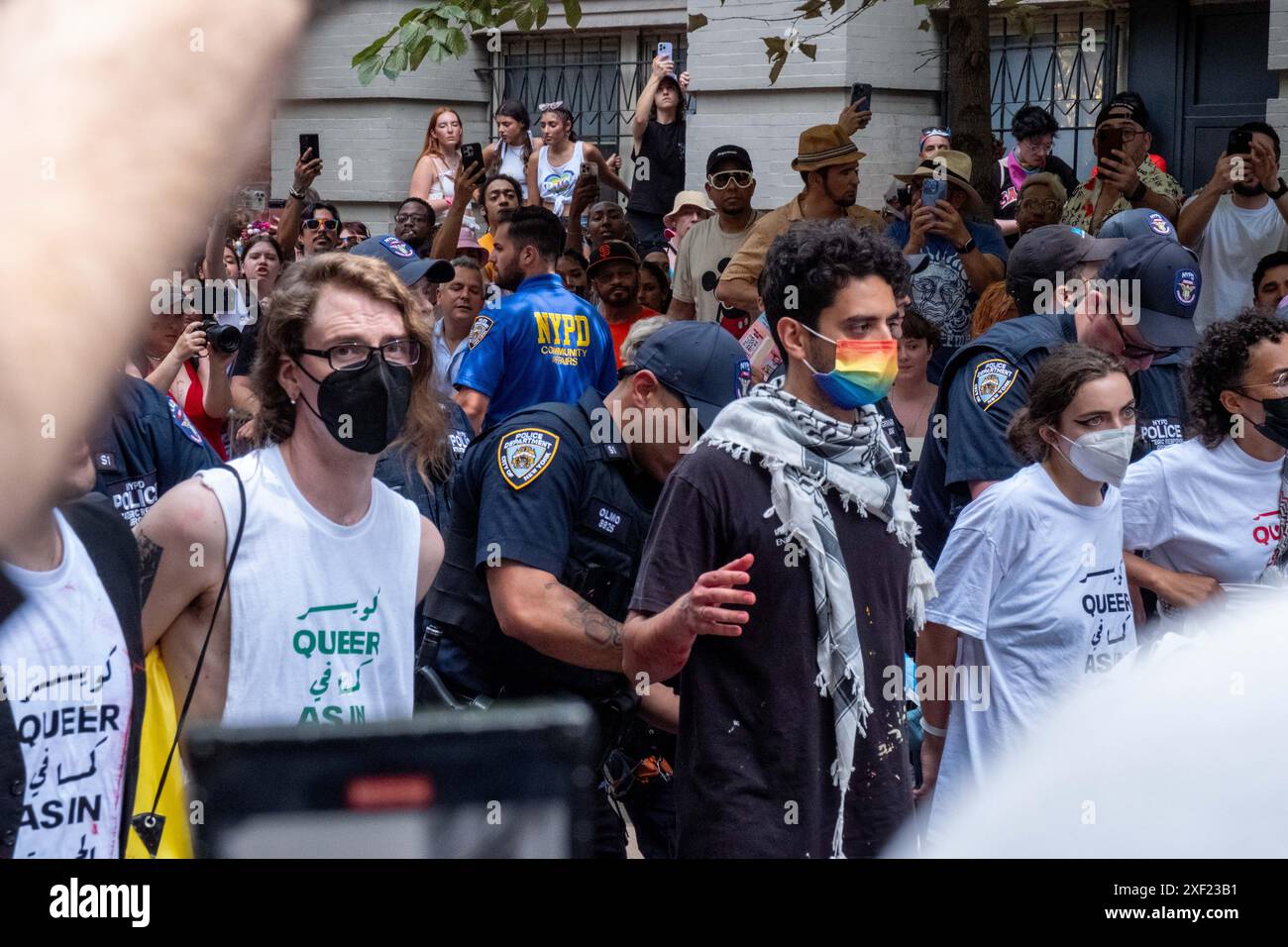 New York, Usa. 30. Juni 2024. Das NYPD verhaftet Demonstranten während der Demonstration. Queere Pro-Palästina-Aktivisten blockierten die NYC Pride Parade in Manhattan. Die Demonstranten saßen in der Mitte der Paraderoute an der Christopher Street und am Waverly Place. Mehrere Verhaftungen wurden durchgeführt und die Parade wurde fortgesetzt, nachdem sie entfernt wurden. Quelle: SOPA Images Limited/Alamy Live News Stockfoto