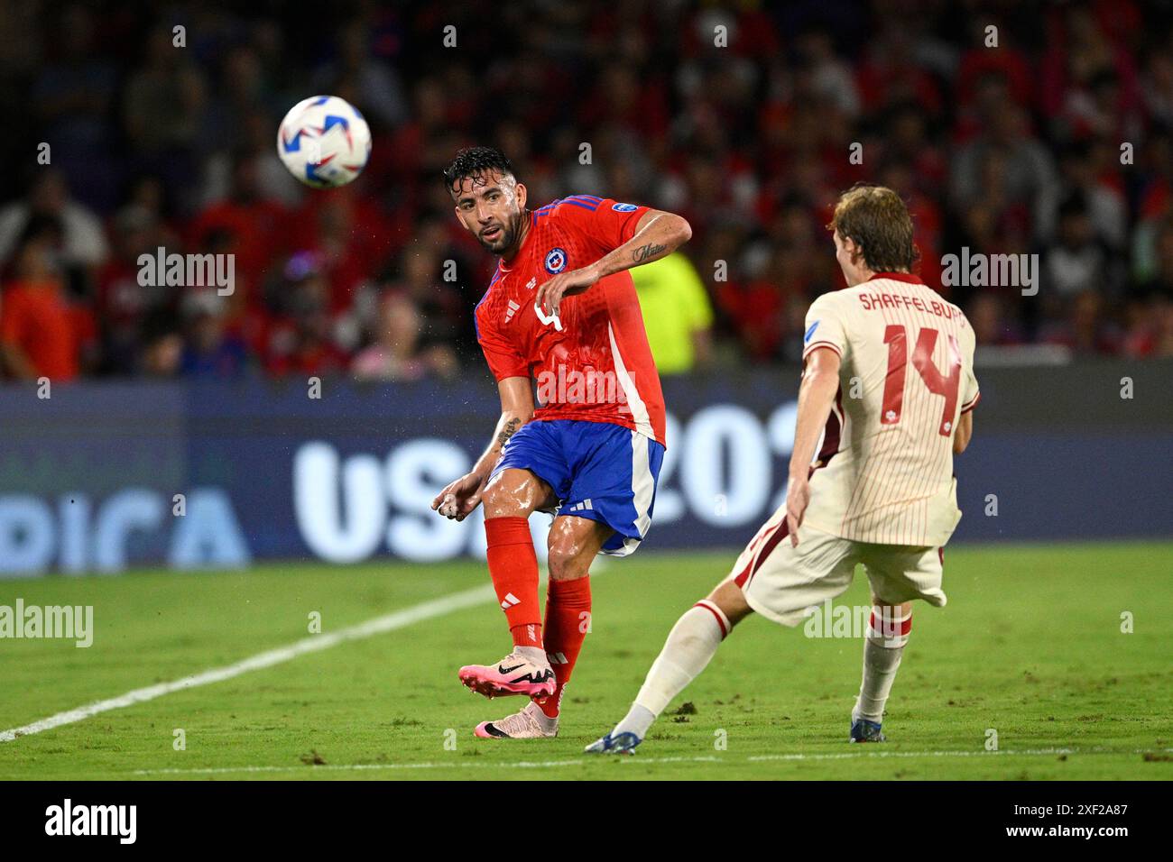 Chile defender Mauricio Isla (4) kicks the ball as Canada striker Jacob Shaffelburg (14) defends during the first half of a Copa America Group A soccer match, Saturday, June 29, 2024, in Orlando, Fla. (AP Photo/Phelan M. Ebenhack) Stockfoto