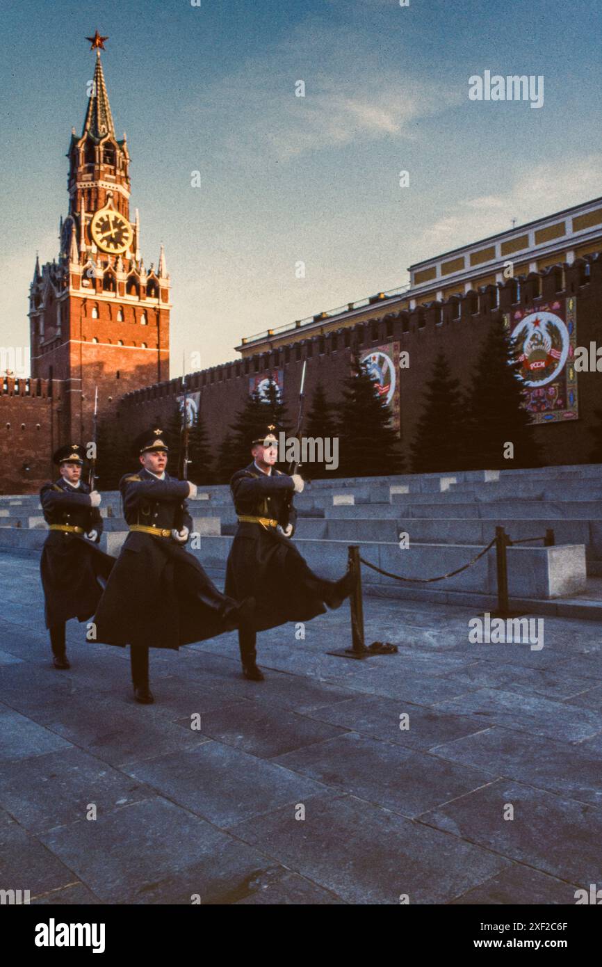 April 1988: Der Wechsel der Ehrenwache des Kreml-Regiments in Lenins Mausoleum vor den Mauern des Kremls auf dem Roten Platz in Moskau, an den Wänden hängen Banner, um den Maifeiertag oder den Internationalen Arbeitertag vorzubereiten. Die Zeit ist 8 Uhr, laut der Uhr auf dem Spassky-Turm des Kremls. Präsident Boris Jelzin entließ die Ehrenwache im Oktober 1993. Stockfoto
