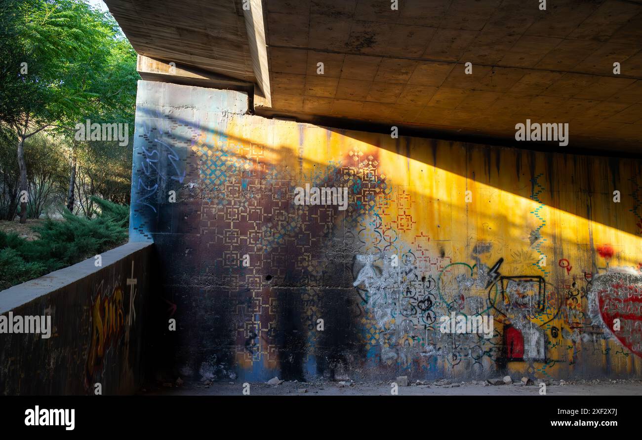 Graffiti an der Mauer unter einer Autobahnbrücke. Stockfoto