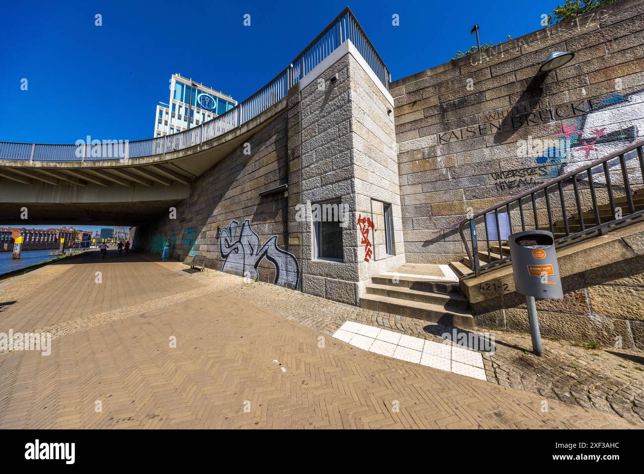 Arisierung-Gedenkstätte zum Gedenken an die rechtswidrige Enteignung jüdischer Mitbürger. Evin Oettingshausens Werk bietet durch zwei Fenster von der Uferpromenade auf der unteren Landung und von oben durch ein horizontales begehbares Fenster einen Blick in einen schachtartigen Raum. Zwei drei Meter hohe Betonwandpaneele hängen im Schachtraum ab, auf denen die Gestaltung der Oberflächenstruktur Schattenabgüsse von Möbeln zeigt. Straße tiefer, Ecke Wilhelm-Kaisen-Brücke, Bremen, Deutschland Stockfoto