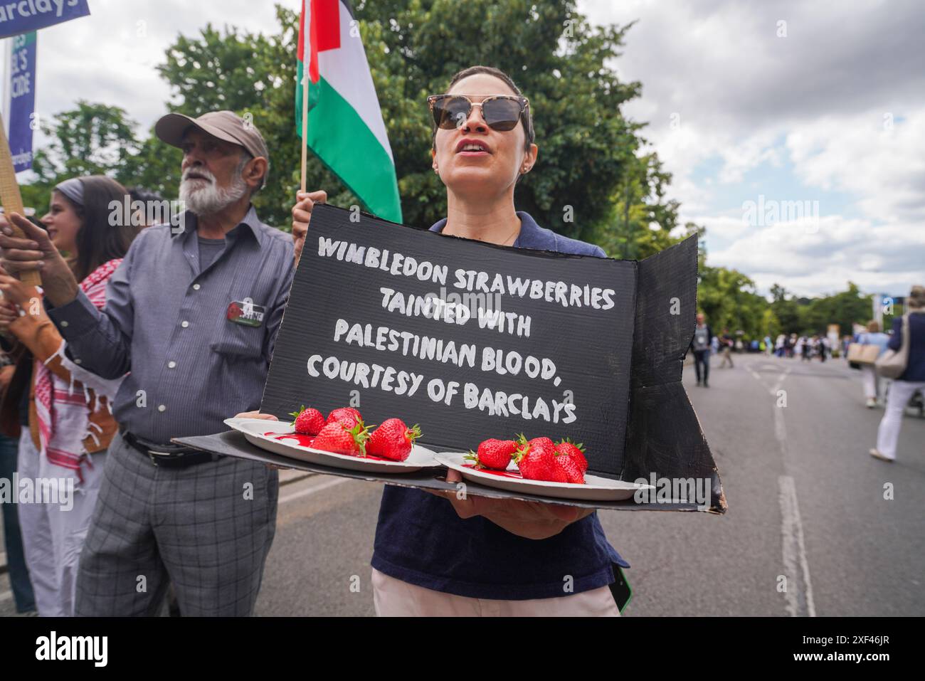 Wimbledon, London, Großbritannien 1. Juli 2024. Pro-palästinensische Demonstranten versammelten sich vor dem All England Lawn Tennis Club am ersten Tag der Wimbledon Championships mit einem riesigen Tennisball und Erdbeeren, die „mit palästinensischem Blut verseucht“ waren, um gegen Barclays Sponsoring des Wimbledon zu demonstrieren, das finanziert wird. Unternehmen, die Waffen und Militärtechnologie liefern, die Israel in Gaza verwendet Credit: Amer Ghazzal/Alamy Live News Stockfoto