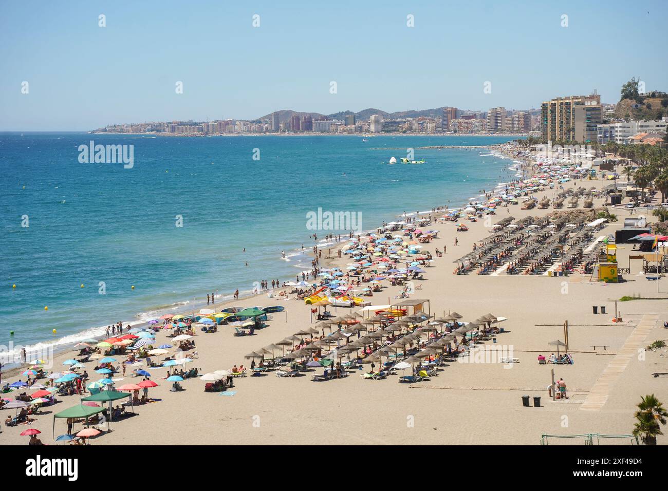 Überfüllter Strand im Sommer mit Sonnenschirmen überfüllter Strand, Fuengirola, Los Boliches, Andalusien, Costa del Sol, Spanien. Stockfoto