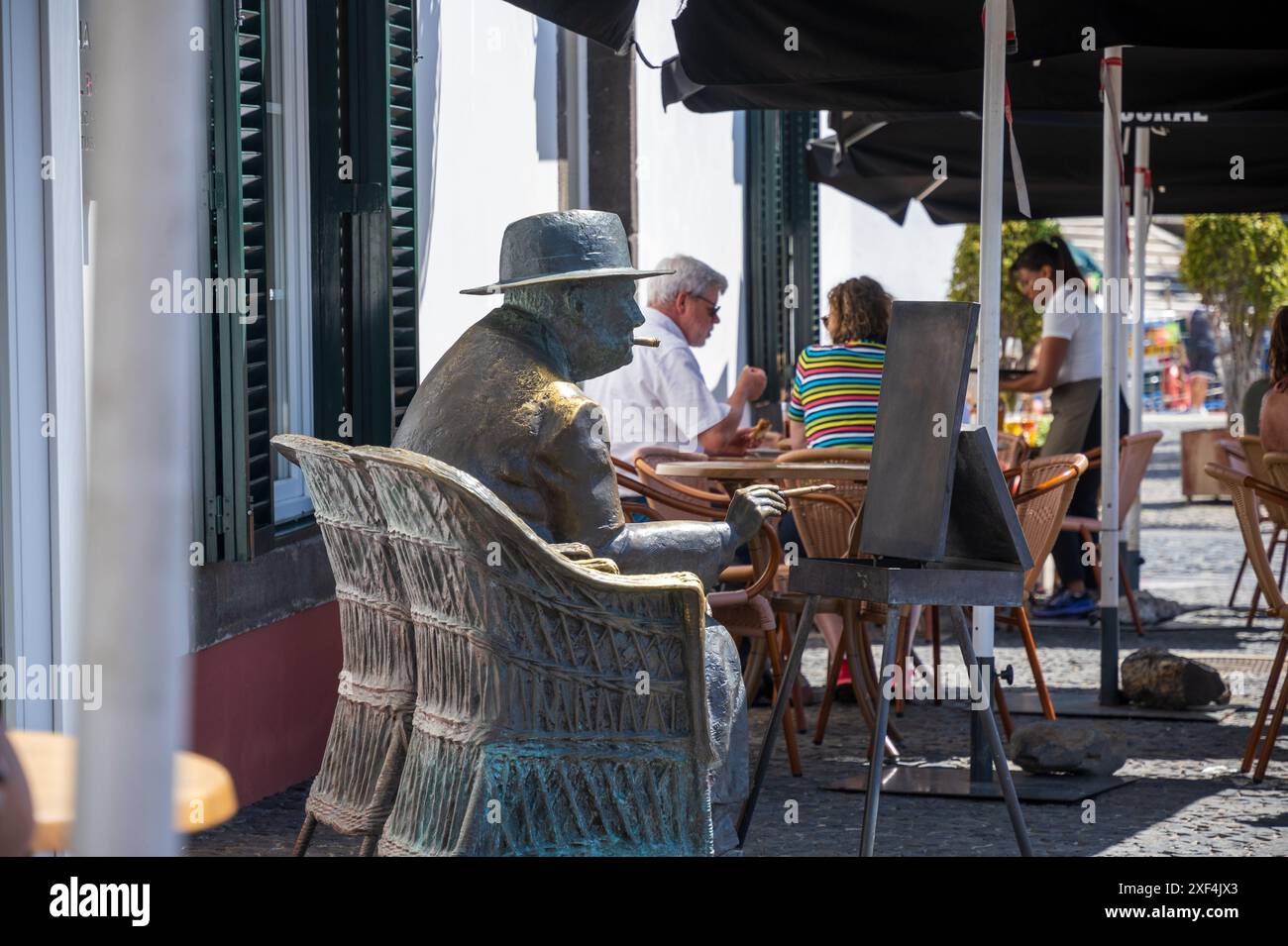 Statue von Sir Winston Churchill zum Gedenken an seine Besuche auf Madeira in der malerischen Bucht von Camara de Lobos . Camara de Lobos Heimat eines lokalen Fischerbootes Stockfoto