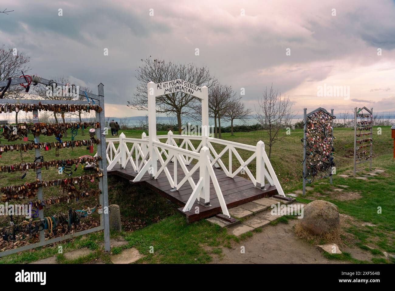 Beliebte weiße Liebesbrücke in Balatonvilagos mit Liebesschlössern mit dem Schild „die Liebe, die hier geboren wird, ist für immer“ Stockfoto