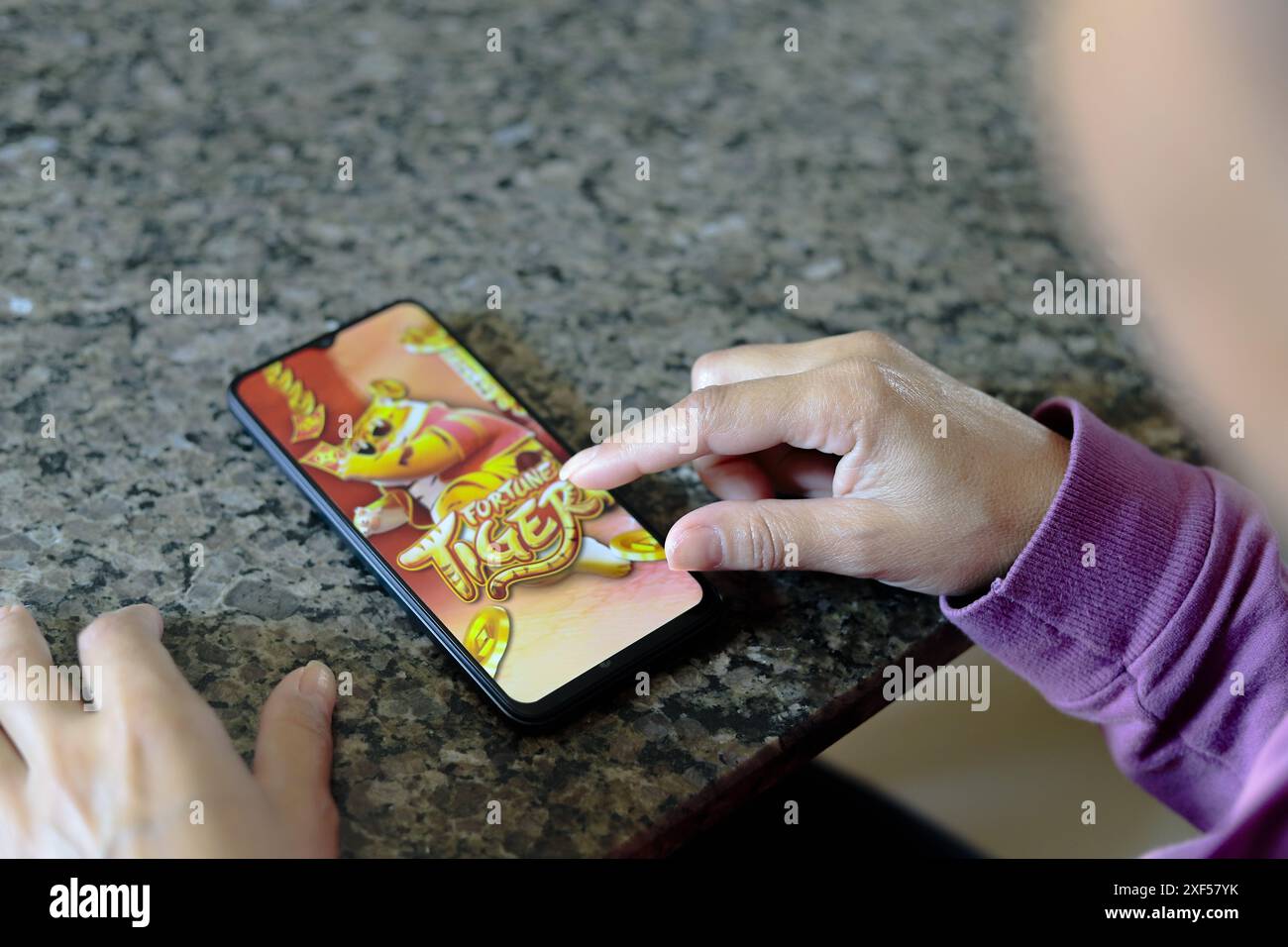 Ivinhema (MS), 07/2024 - Pessoa jogando o o Fortune Tiger, também chamado de Jogo do Tigrinho kein Smartphone. Organizações kriminosas estariam usando Stockfoto