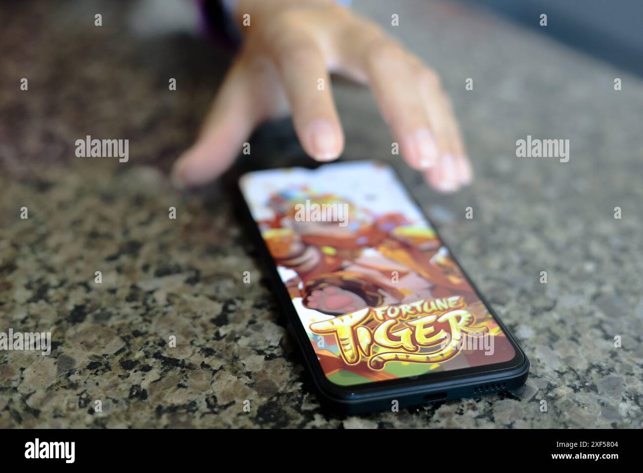 Ivinhema (MS), 07/2024 - Pessoa jogando o o Fortune Tiger, também chamado de Jogo do Tigrinho kein Smartphone. Organizações kriminosas estariam usando Stockfoto