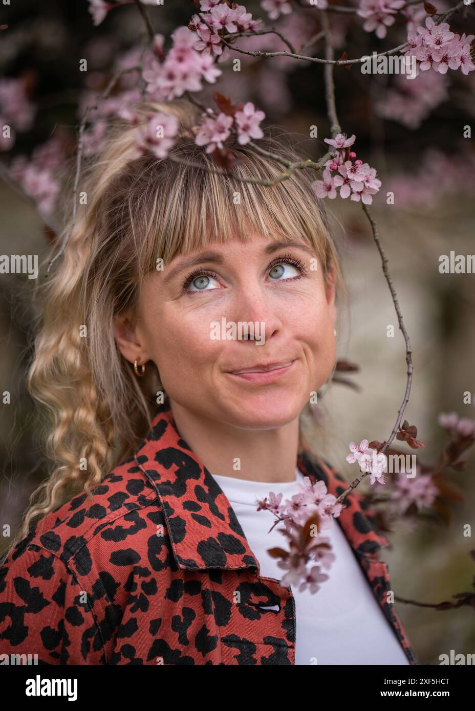 Nahaufnahme Porträt eines fröhlichen, süßen Mädchens mit blonden Haaren, die nach oben schauen. Die Frau machte eine fröhliche Grimasse auf ihrem Gesicht Stockfoto