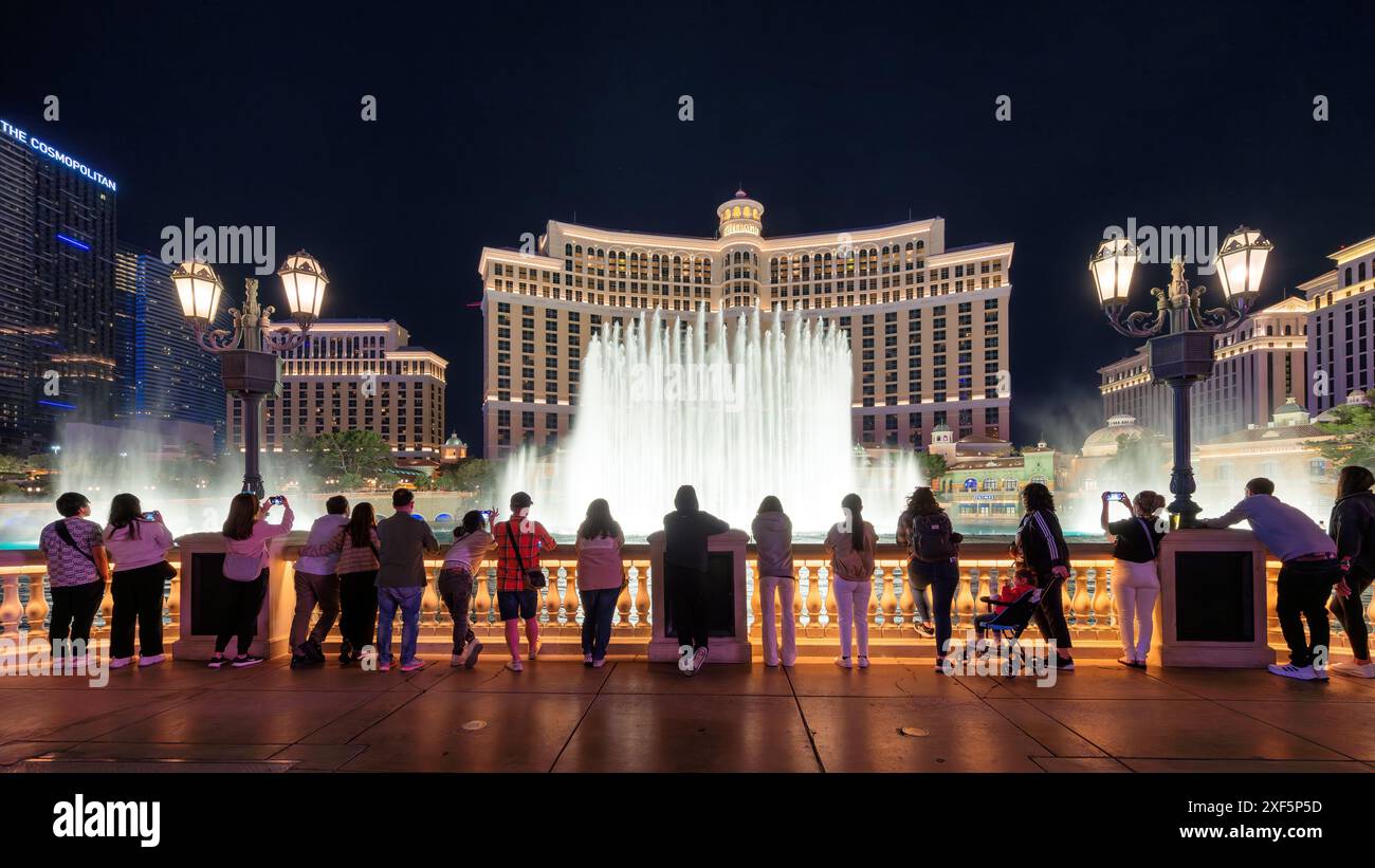 Die Leute genießen den Blick auf die tanzenden Springbrunnen im Bellagio Hotel and Casino bei Nacht Stockfoto