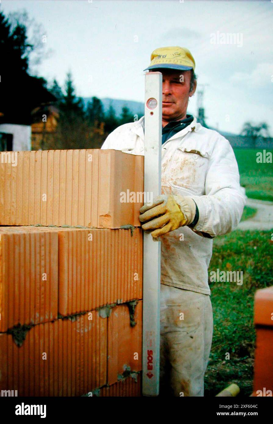 mason baut eine Ziegelmauer, Bauarbeiten auf einer Baustelle mason baut eine Ziegelmauer Stockfoto