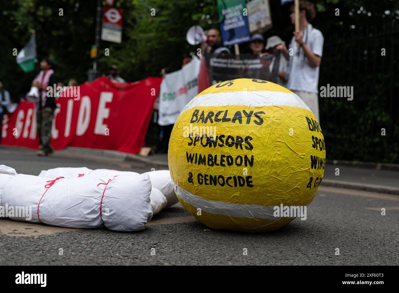 London, Großbritannien. Juli 2024. Eine Tennisballstütze, auf der während der Demonstration „Barclays Sponsoren Wimbledon und Genozid“ steht. Pro-palästinensische Aktivisten fordern Wimbledon auf, Barclays wegen der finanziellen Beziehungen des Unternehmens zu Israel „fallen zu lassen“. Quelle: SOPA Images Limited/Alamy Live News Stockfoto