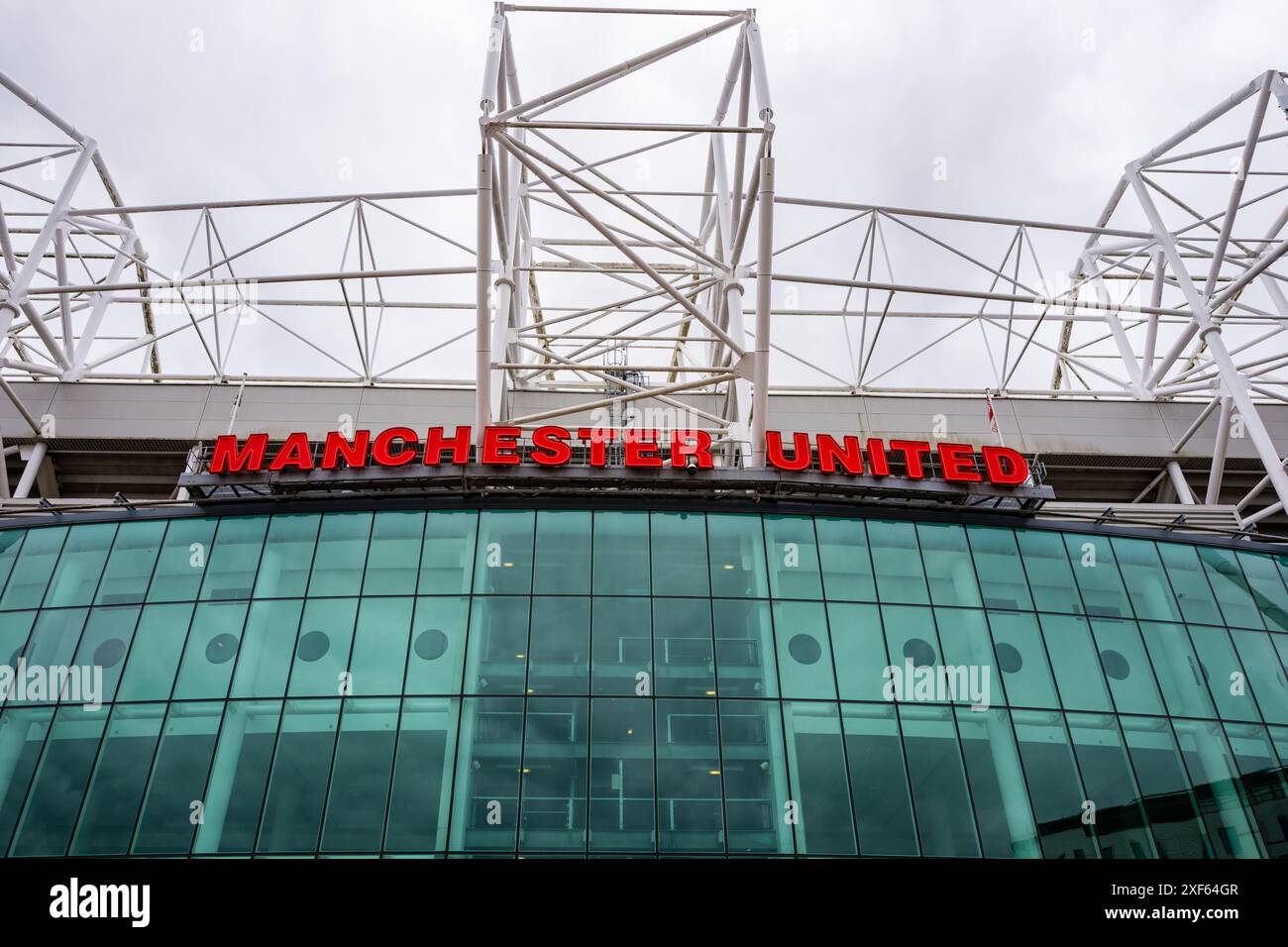 Manchester Trafford UK 29. Juni 2024. Ikonischer Eingang zum Fußballstadion mit großem rotem Schild unter einem bewölkten Himmel. Stockfoto