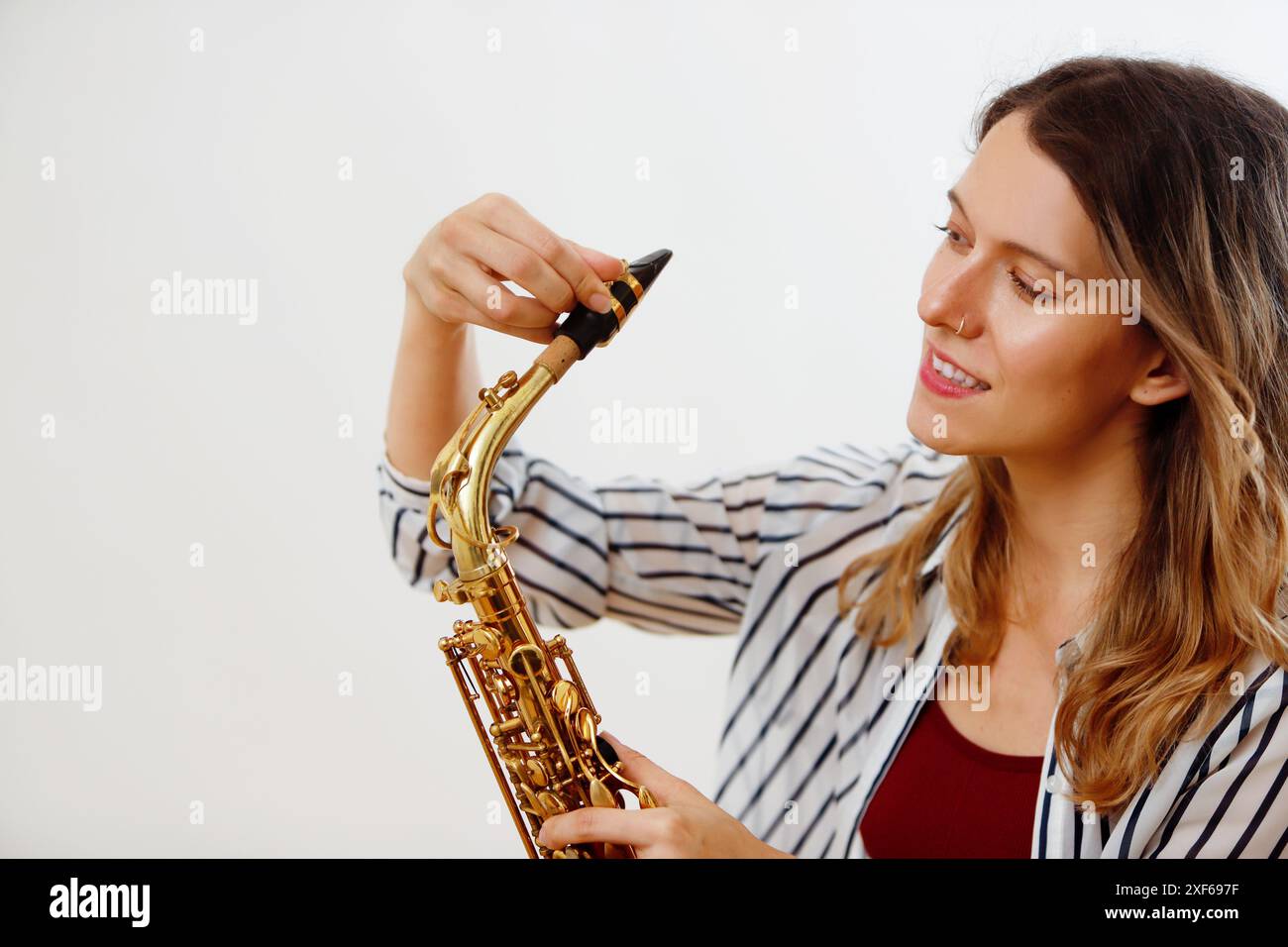 Frau, die Saxophon-Mundstück justiert Stockfoto