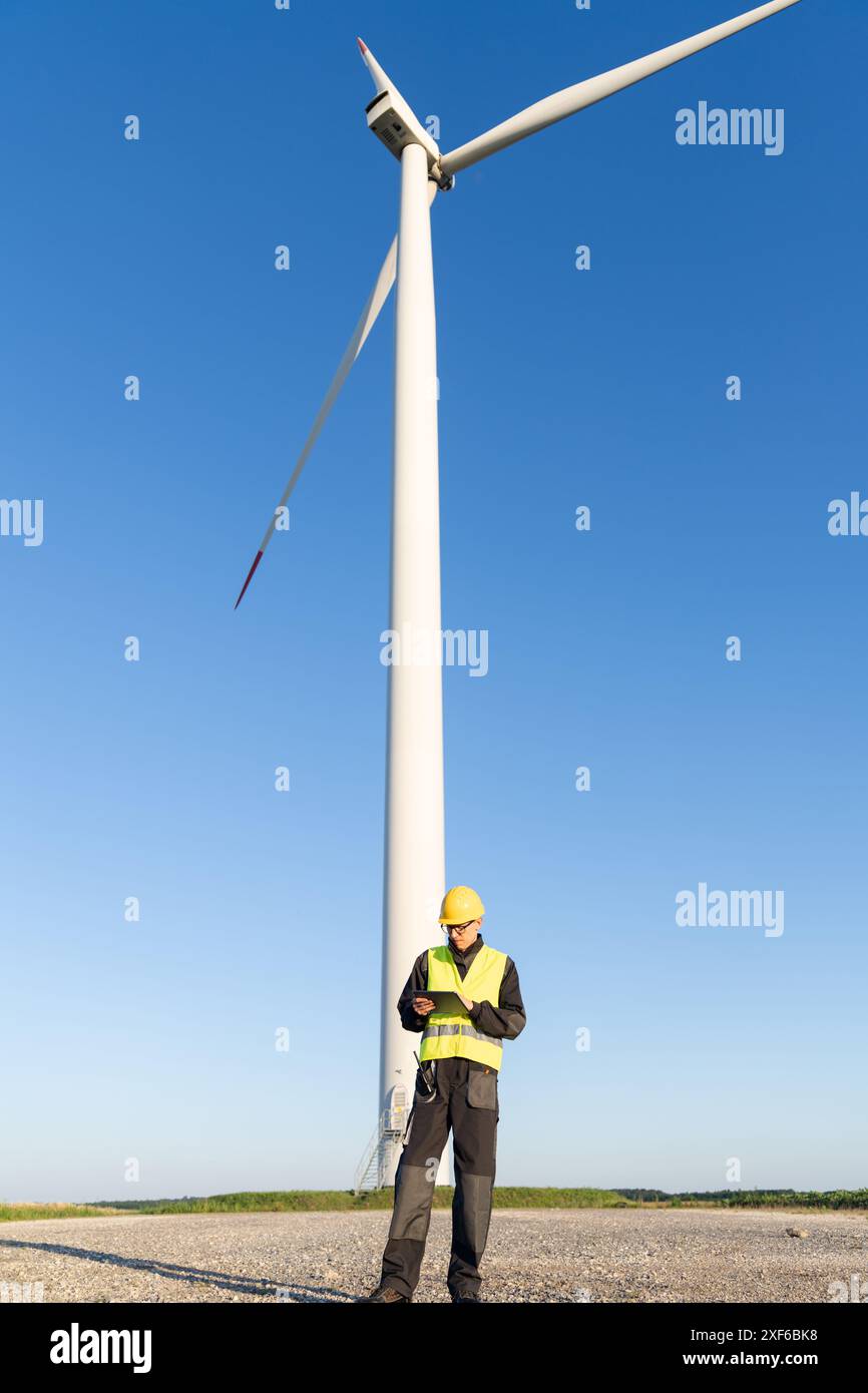 Ein Ingenieur mit einem digitalen Tablet arbeitet an einem Bereich von Windturbinen. Stockfoto