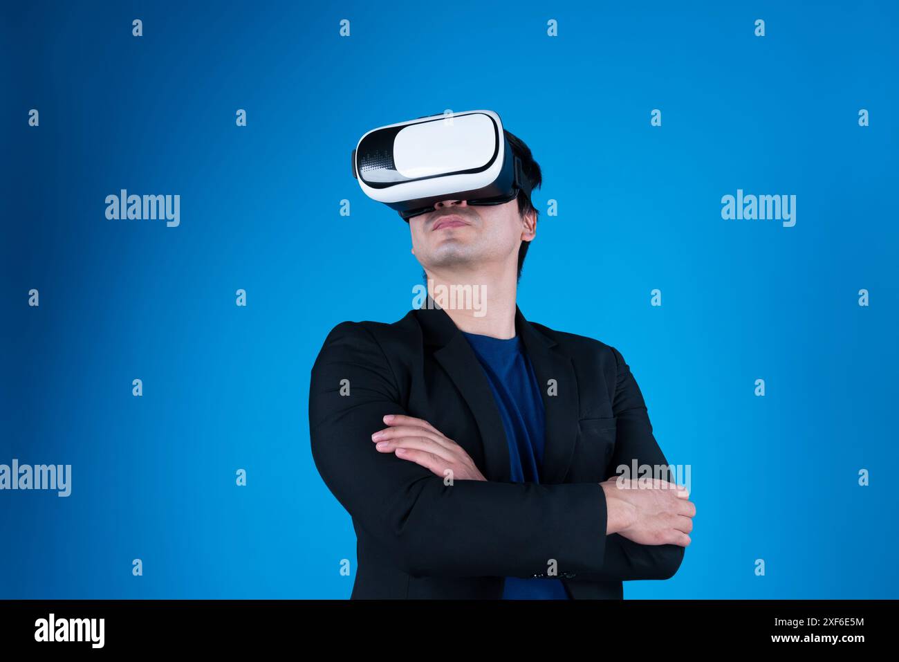 Profil eines Geschäftsmanns, der den Arm kreuzt und ein VR-Gerät trägt, um Metaverse, isolierte, blaue Hintergrundkommunikation mit futuristischer Analyse zu verbinden Stockfoto