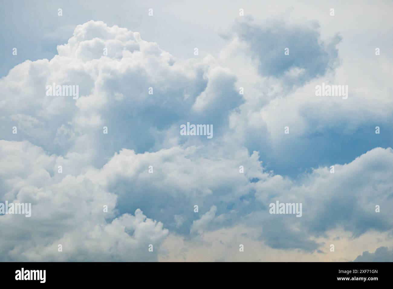 Graublauer Himmel mit weißen flauschigen Wolken, natürlicher Fotohintergrund, aufgenommen in Frankreich Stockfoto