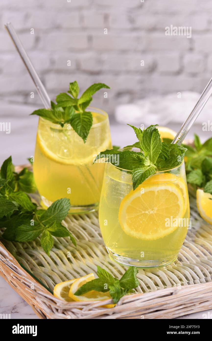 Der Limoncello Spritz ist ein leichter, erfrischender, kühler Cocktail mit Zitronenlikör, Prosecco und Mineralwasser, Minze und einer Scheibe Zitrone. Stockfoto