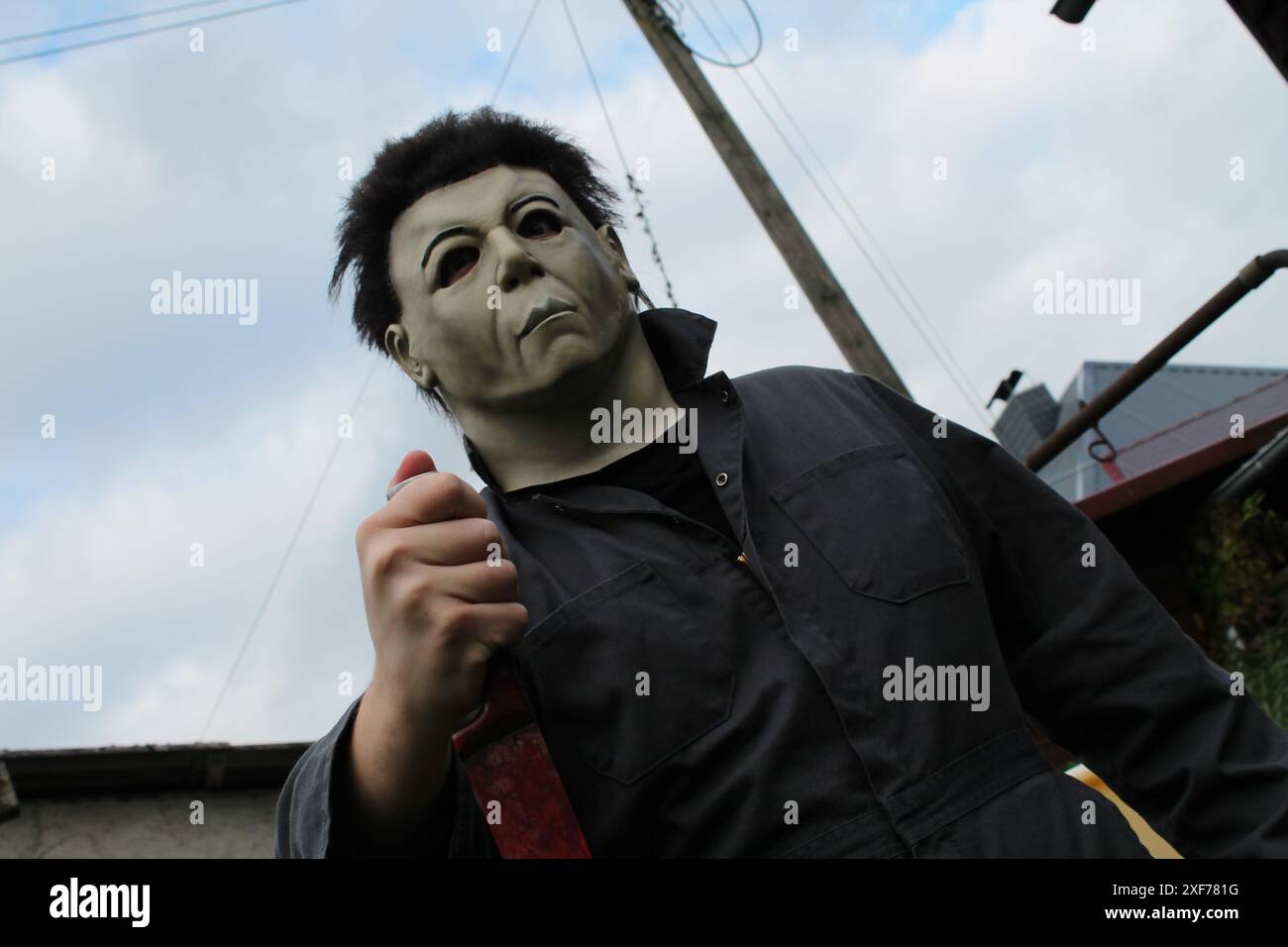 Hier sehen Sie Myers von Halloween Auferstehung als Cosplay mit originellen Requisiten in sehr epischer Pose Stockfoto