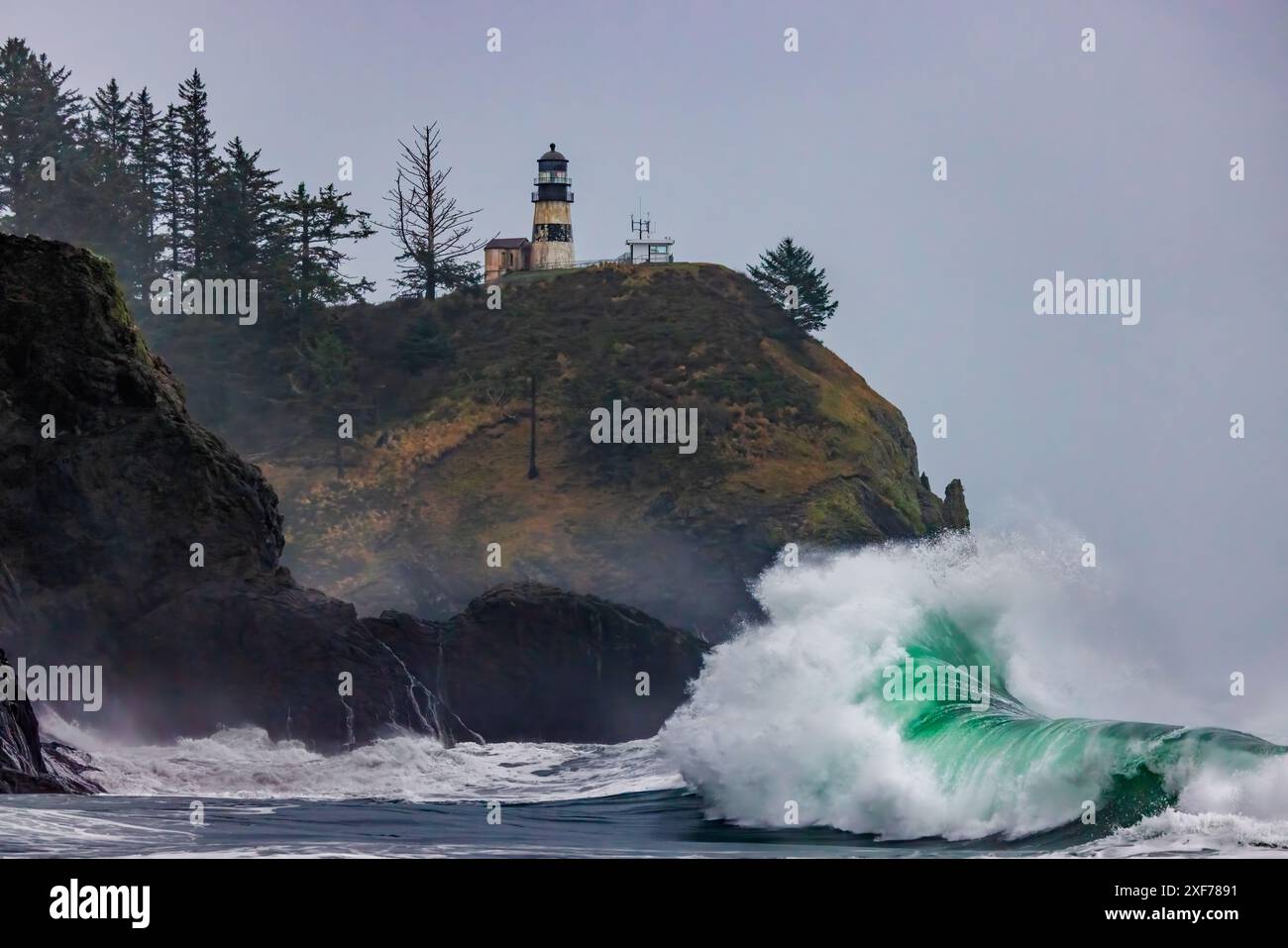 Die Wellen stürzen unter dem Leuchtturm im Cape Desappointment State Park, Washington State, USA. Stockfoto