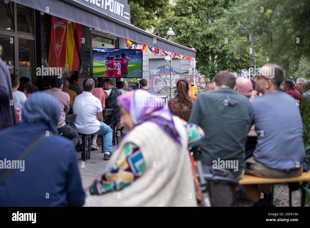 Gäste vor einer Bar in der Reichenberger Straße in Berlin-Kreuzberg verfolgen das Spiel Türkei gegen Portugal anlässlich der Fußballeuropameisterschaft UEFA EURO 2024. / Gäste vor einer Bar in der Reichenberger Straße in Berlin-Kreuzberg sehen das Spiel zwischen der Türkei und Portugal während der Fußball-Europameisterschaft UEFA EURO 2024. Schnappschuss-Fotografie/K.M.Krause *** Gäste vor einer Bar in der Reichenberger Straße in Berlin Kreuzberg sehen das Spiel zwischen der Türkei und Portugal während der Fußball-Europameisterschaft UEFA EURO 2024 Gäste vor einer Bar in der Reichenberger Straße in B Stockfoto