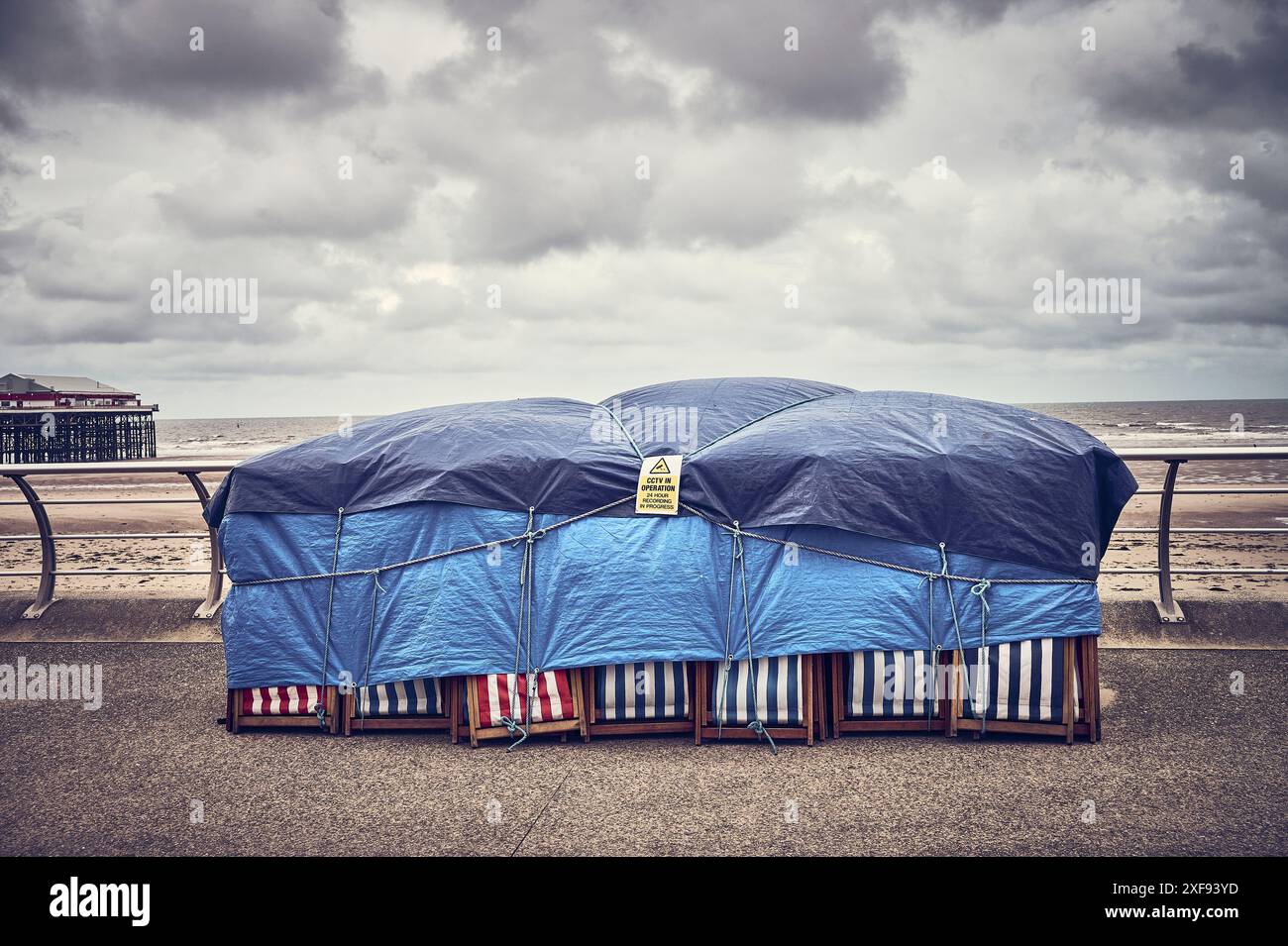 Liegestühle, die bei schlechtem Wetter mit Laken bedeckt waren, am Strand von blackpool Stockfoto