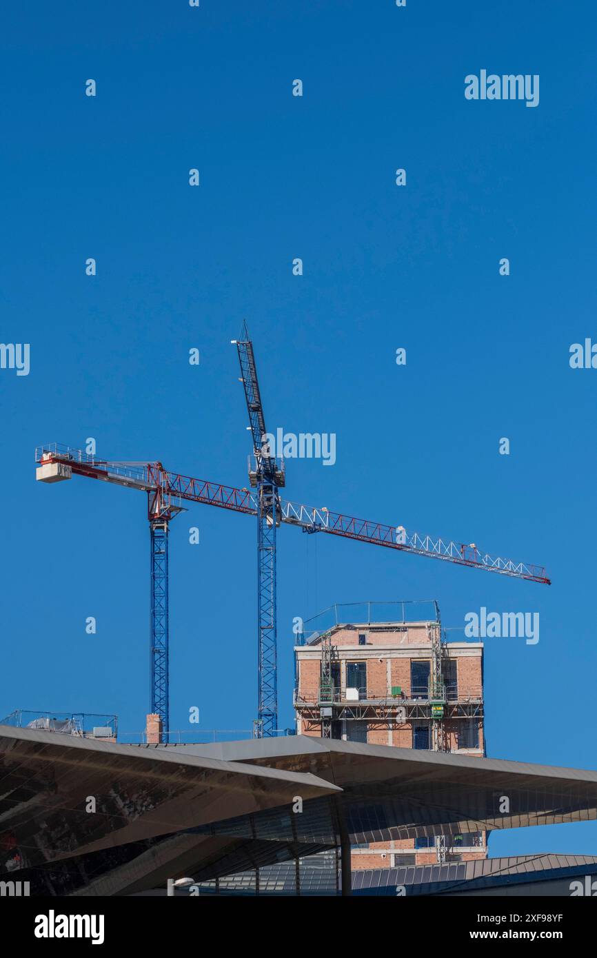 Baustelle mit Kränen und teilweise errichteter Struktur vor klarem blauem Himmel, Poblenou, Barcelona, Katalonien, Spanien Stockfoto