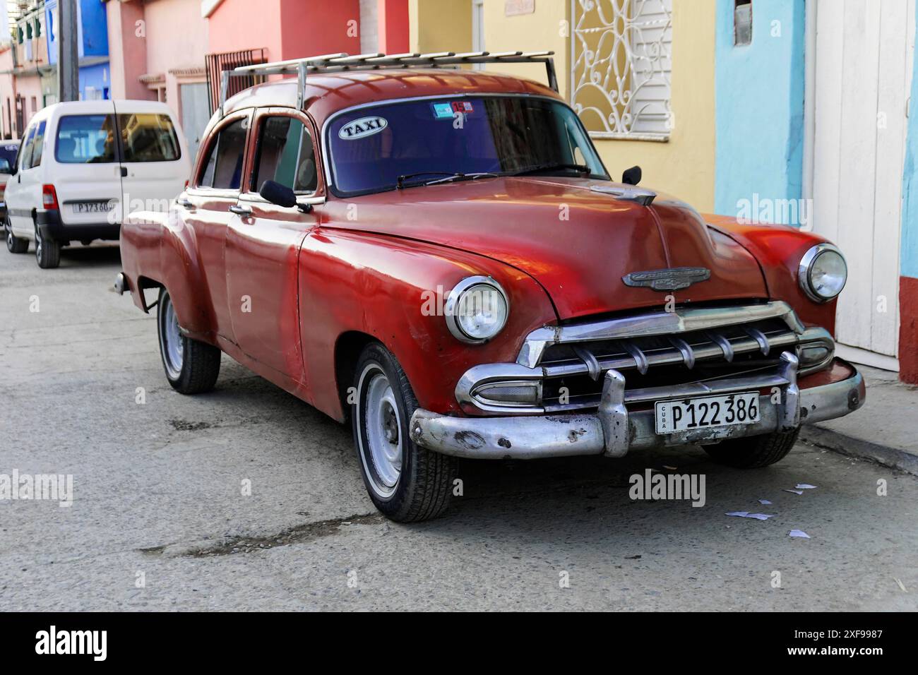 Trinidad, Kuba, Grosse Antillen, Karibik, Mittelamerika, Amerika, Eine rote, klassische Limousine steht auf einer Stadtstraße, die als Taxi gekennzeichnet ist Stockfoto