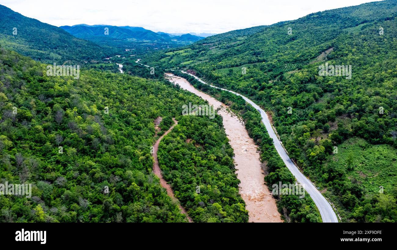 Aus der Vogelperspektive auf den mächtigen Mekong, der sich morgens während der Regenzeit vor den üppigen grünen Bergen schlängelt. Stockfoto