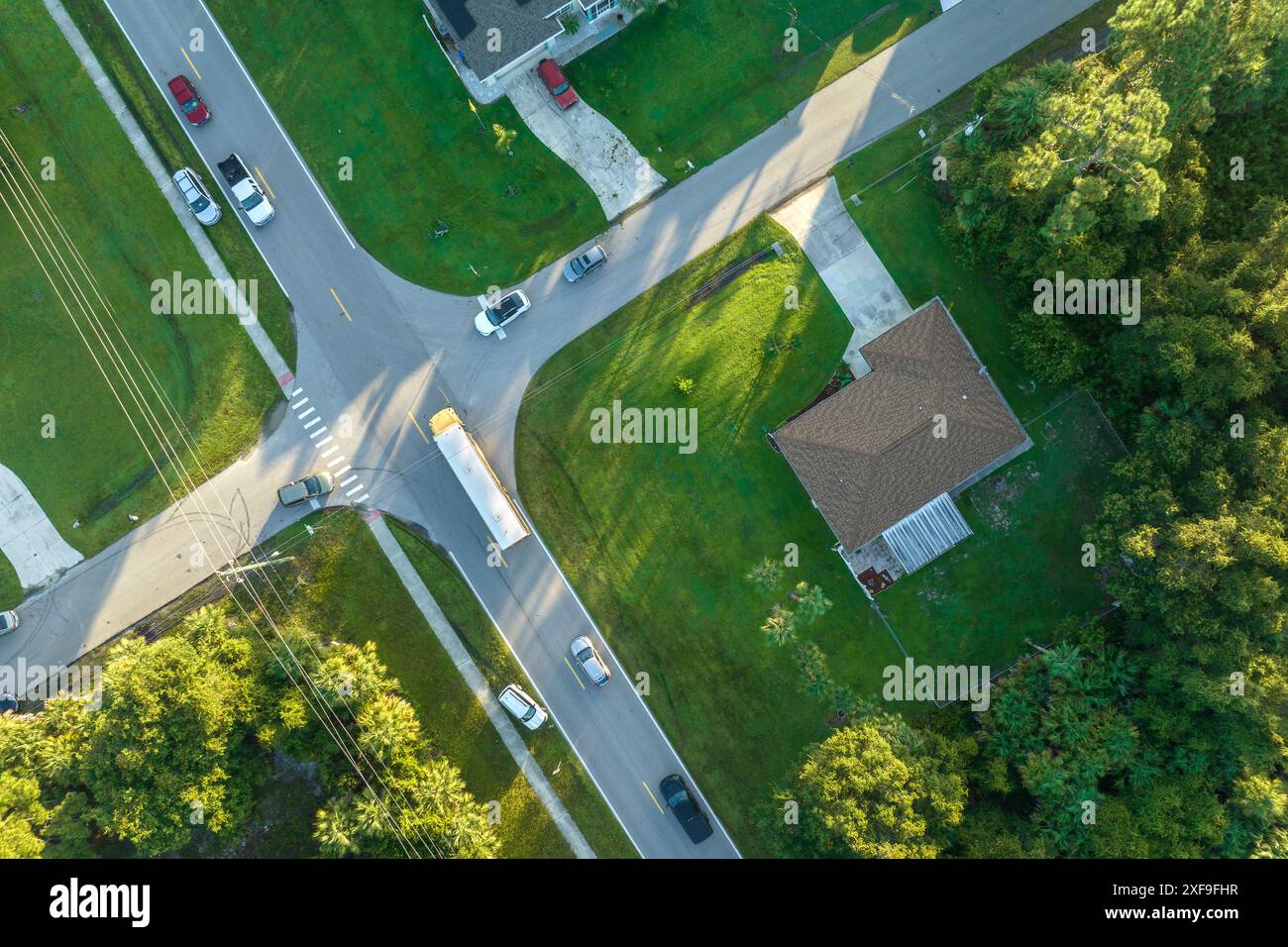 Draufsicht auf den klassischen gelben schulbus der usa, der auf der Straße der ländlichen Stadt fährt, um Kinder für ihre kleinen Kinder am frühen Morgen abzuholen. Öffentlich Stockfoto