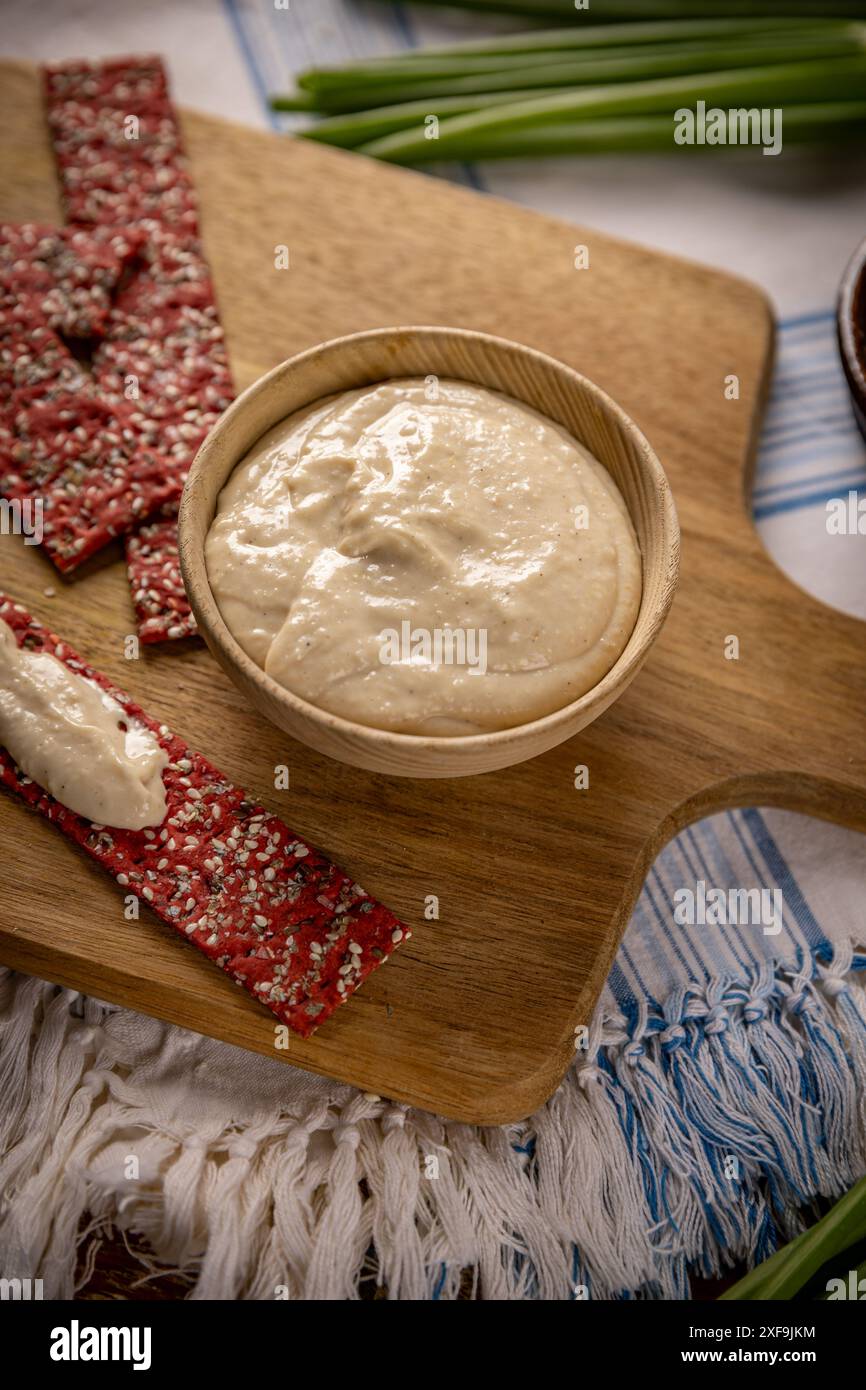 Köstlicher hausgemachter Hummus serviert mit Rote-Bete-Crackern Stockfoto