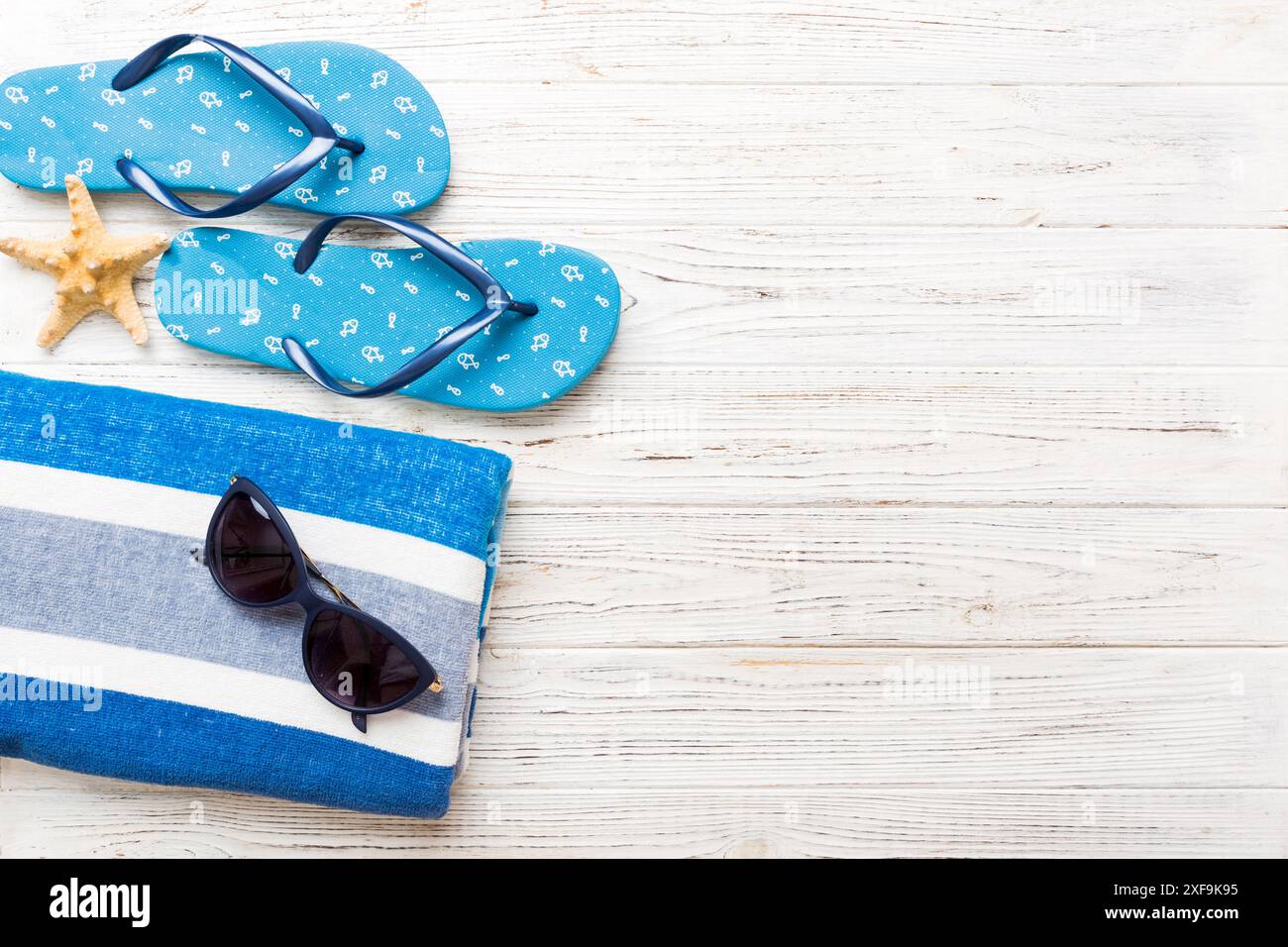 Sommer Sonnenbaden Strand Hintergrund, Sonnenbrille, Flip Flops und Handtuch, Draufsicht mit Kopierraum für Text. Stockfoto