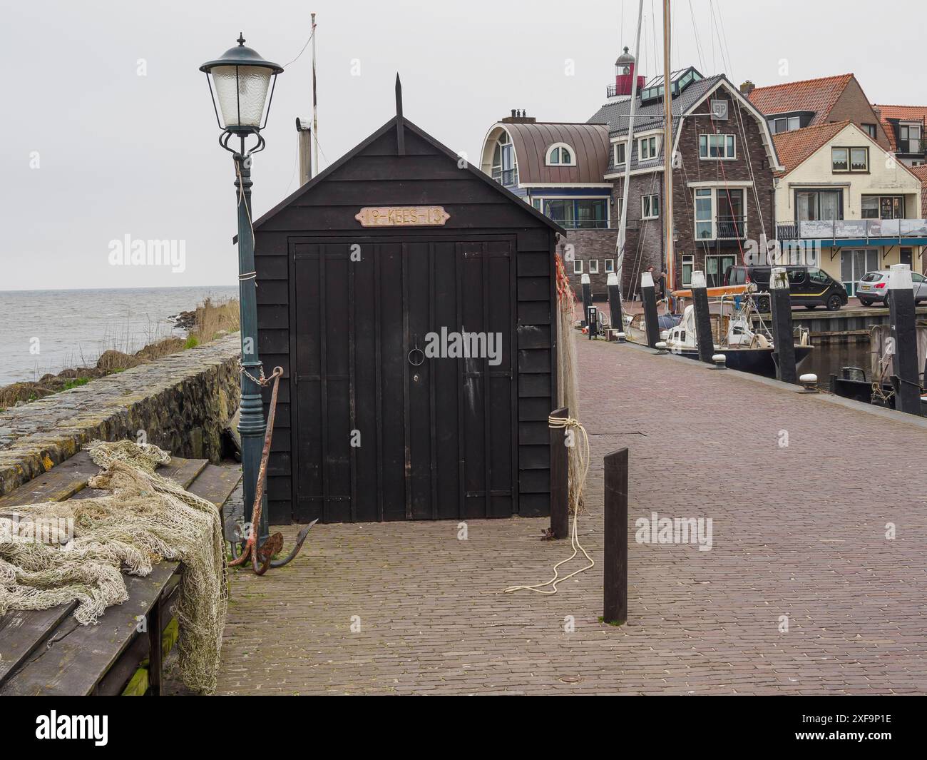 Holzschuppen in der Nähe der Küste mit Booten und Häusern im Hintergrund, urk, niederlande Stockfoto