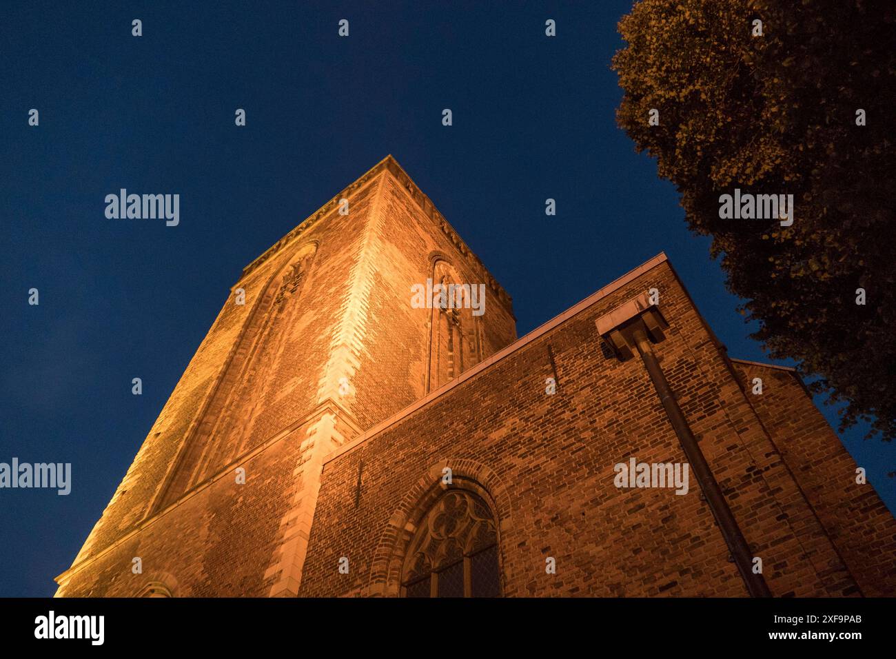 Nachtaufnahme eines beleuchteten Kirchturms mit stimmungsvollem Ambiente, utrecht, niederlande Stockfoto